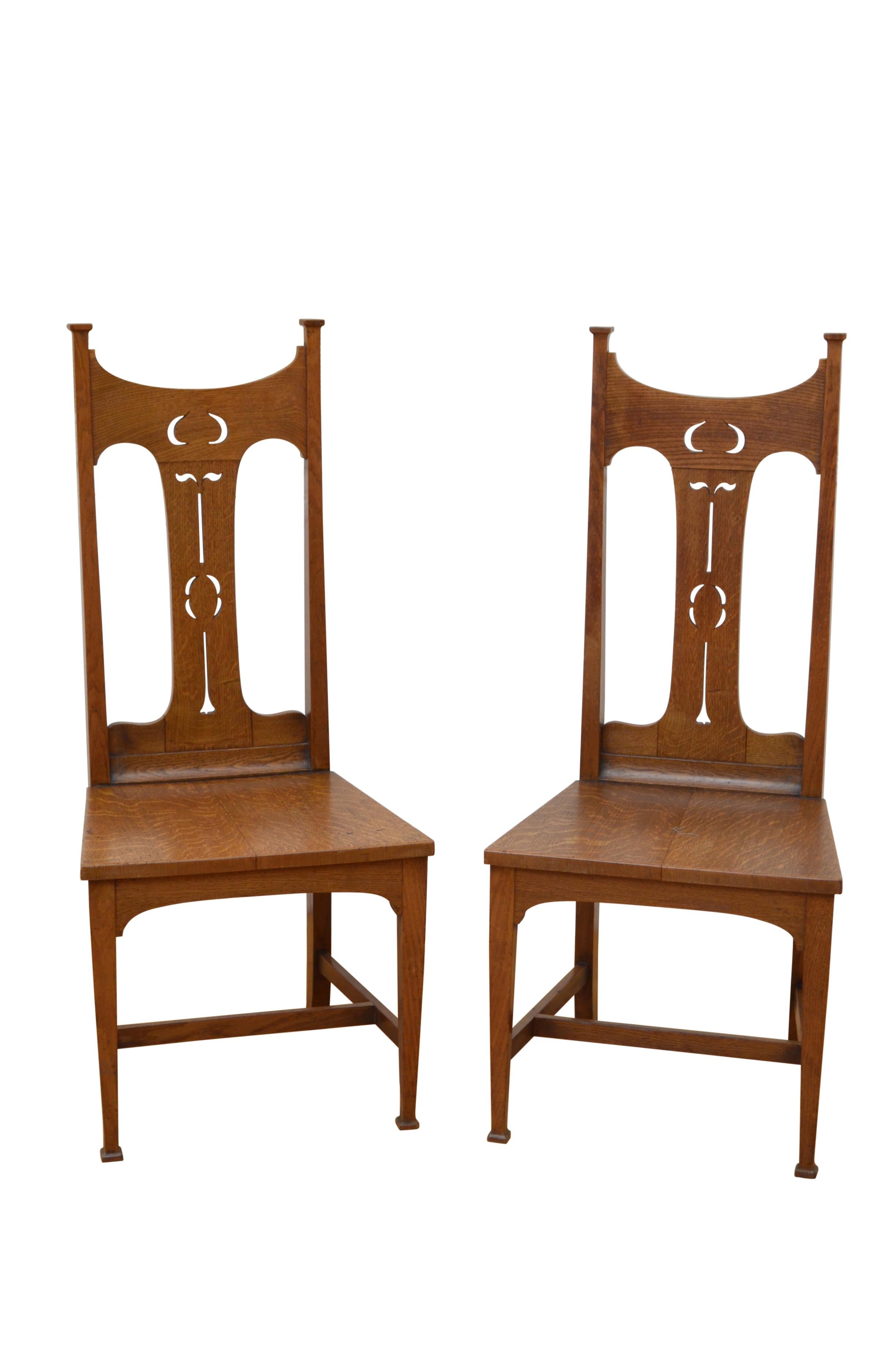 K0544 Pair of superb solid oak Arts and Crafts chairs, each with stylish carved back, generous seat with newly made cushion and tapered legs. This pair of antique chairs retains original finish, mellow colour and patina, all in home ready condition.