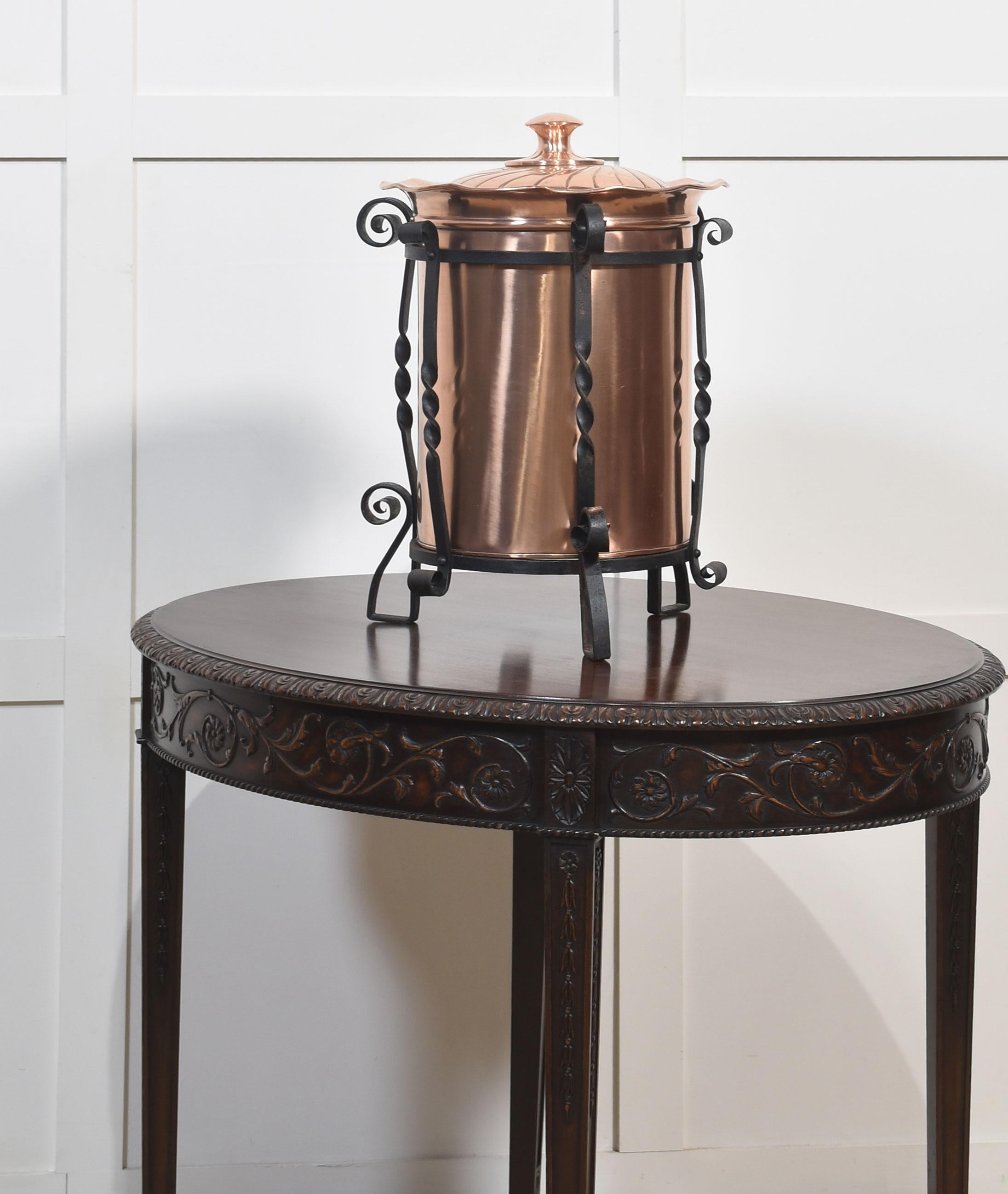 Arts and Crafts circular copper coal bucket within a protective black wrought-iron stand, to the dome-topped lid decorated above the cylindrical body. All raised up on shaped feet.
Dimensions
Height 20.5 Inches
Width 13 Inches
Depth 13 Inches