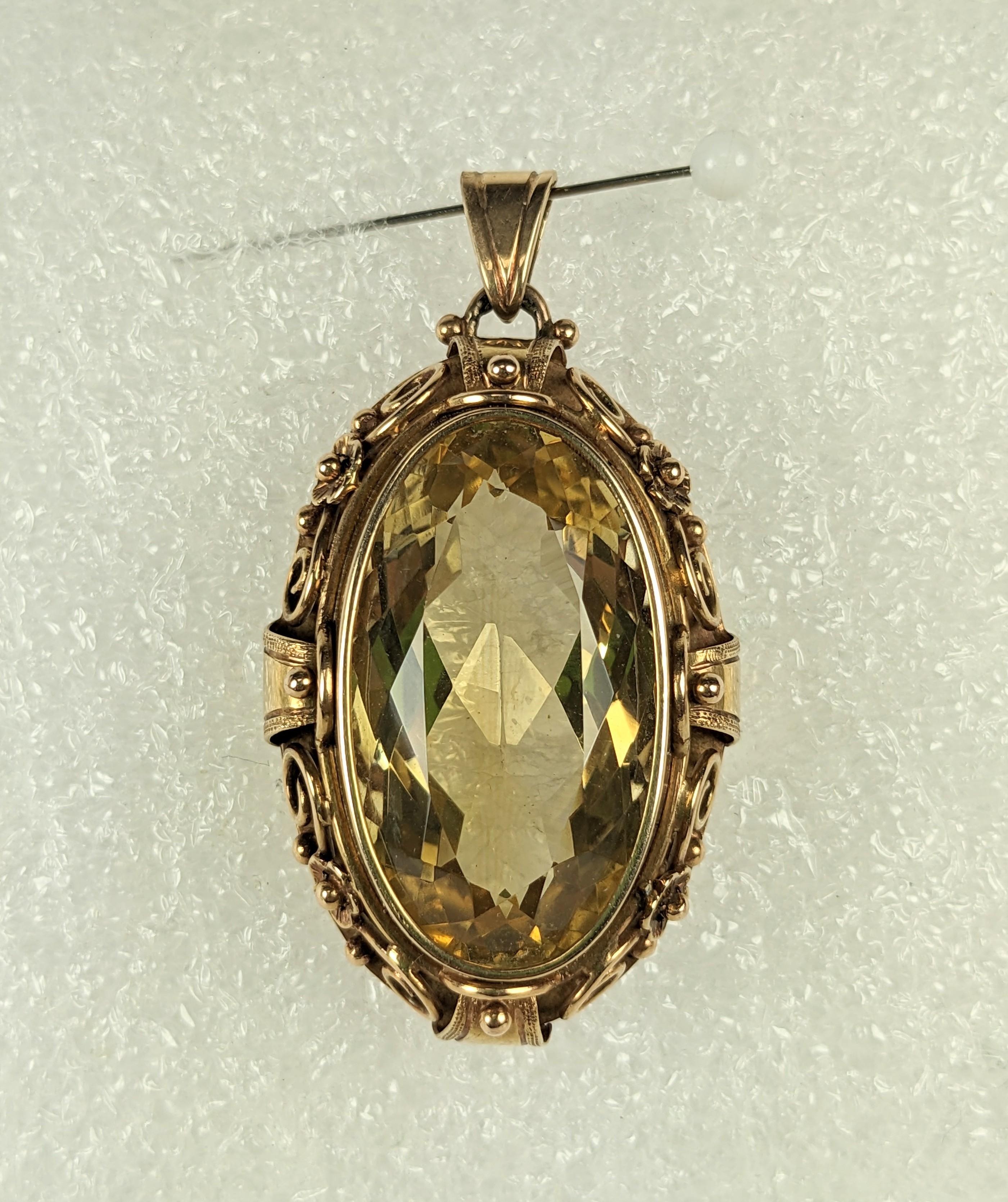 European Arts and Crafts Citrine Pendant from the early 20th Century, circa 1930.  A large and fine oval citrine (27mm x 15mm) is set in a heavy 14k pinkish gold floral Arts and Crafts setting with floral and scrollwork motifs. Marked 585 (14k).