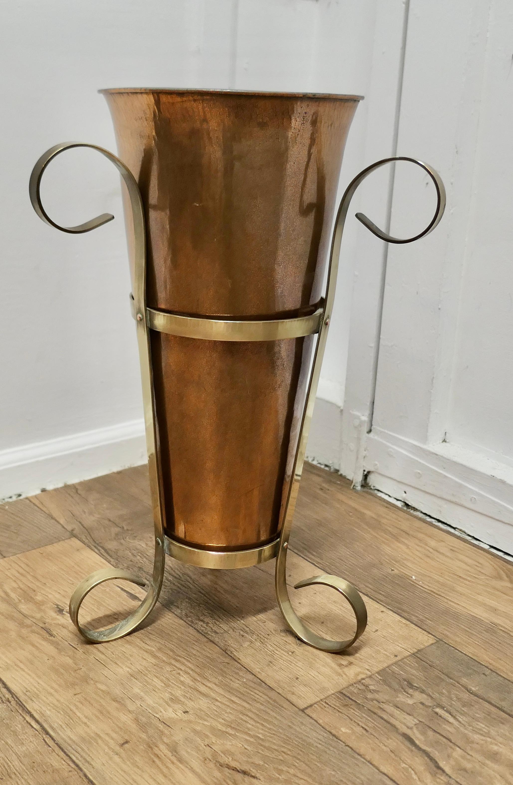 Arts and Crafts Copper and Brass Umbrella Stand

An unusual and attractive piece, the copper receptacle is set in a very attractive curvy brass stand
The stand is 22” tall and 13” in diameter 
TVY162