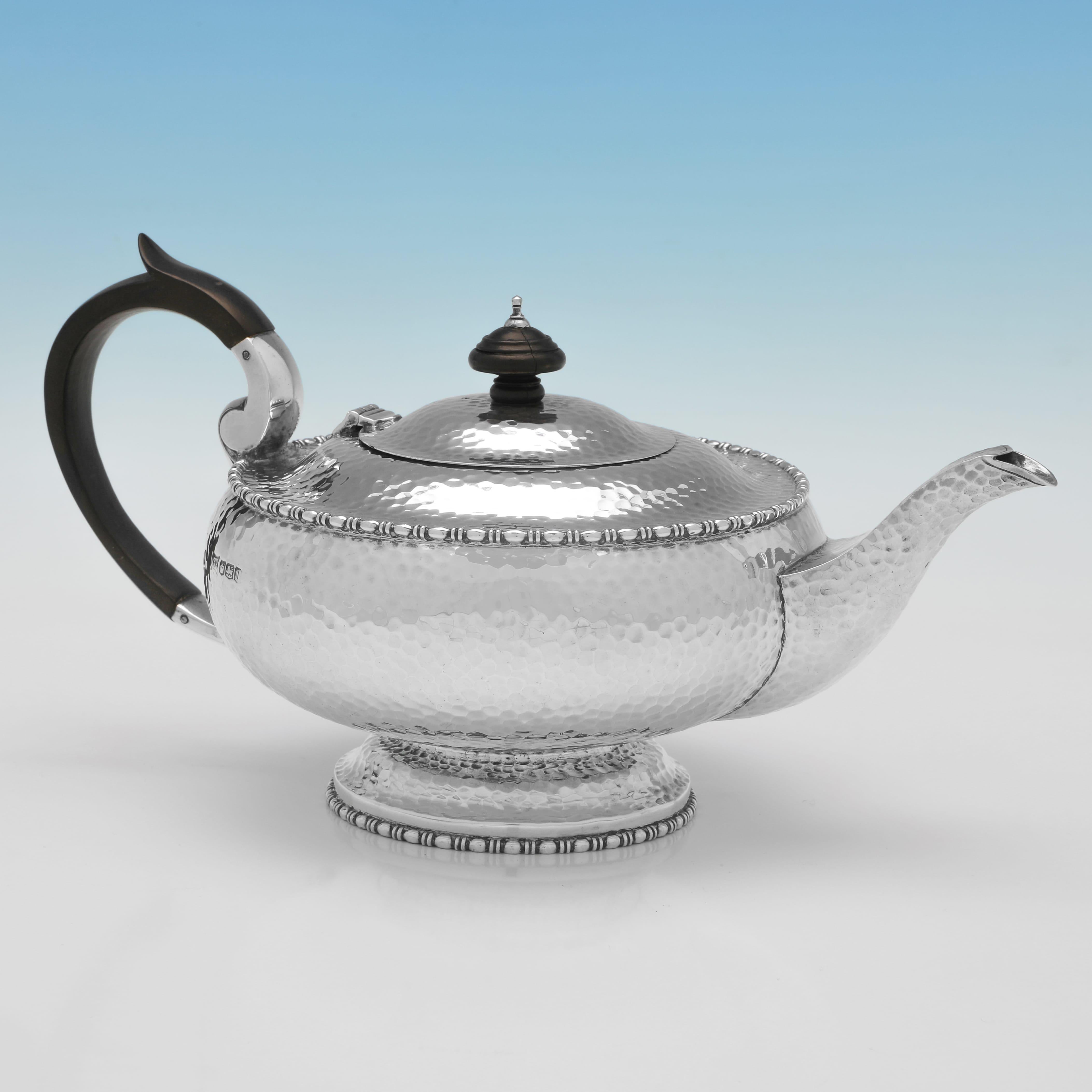 Cette étonnante théière Art déco en argent massif, poinçonnée à Sheffield en 1928 par les célèbres orfèvres Walker & Hall, est un superbe exemple du design britannique du début du XXe siècle. Fabriquée en argent massif, la théière présente une
