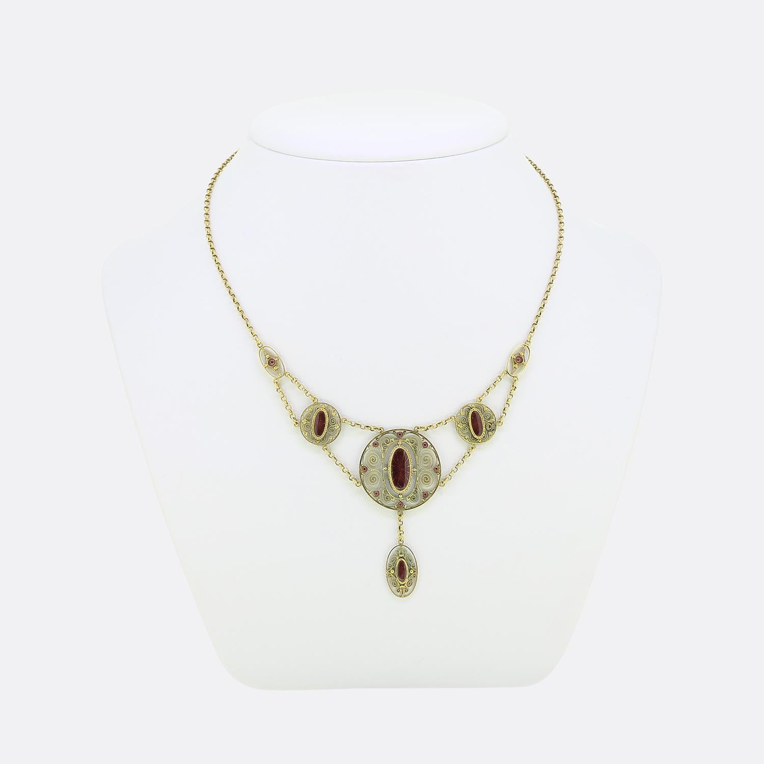 Here we have a delightful festoon necklace crafted at a time when the Arts and Crafts movement was at its pinnacle. A 14ct yellow gold belcher style chain suspends multiple matching round and oval shaped motifs consisting of ornate curvaceous