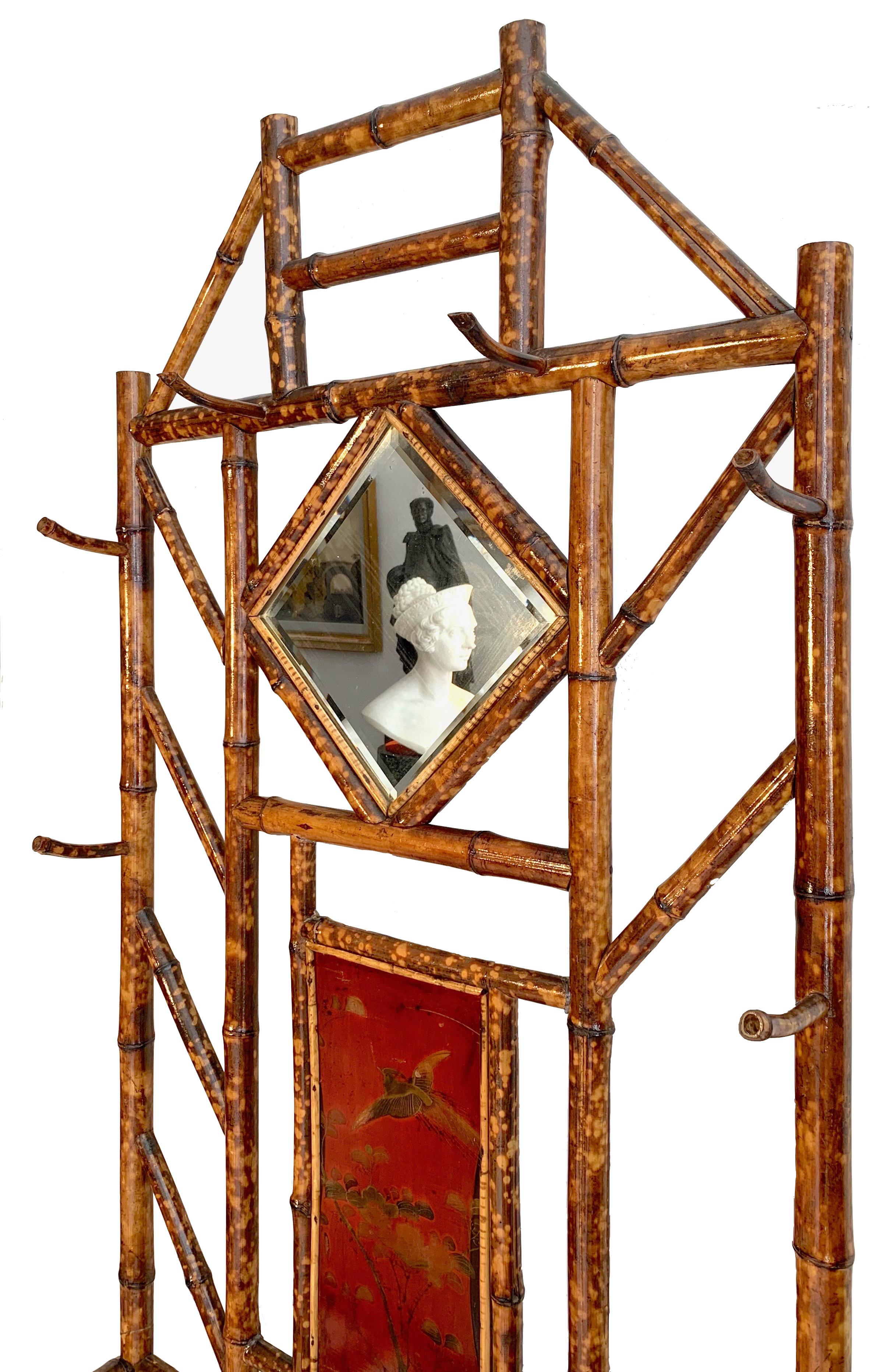 This elegant and rare bamboo wardrobe is decorated with painted lacquer panels in the Japanese taste and retains the original faceted mirror.
