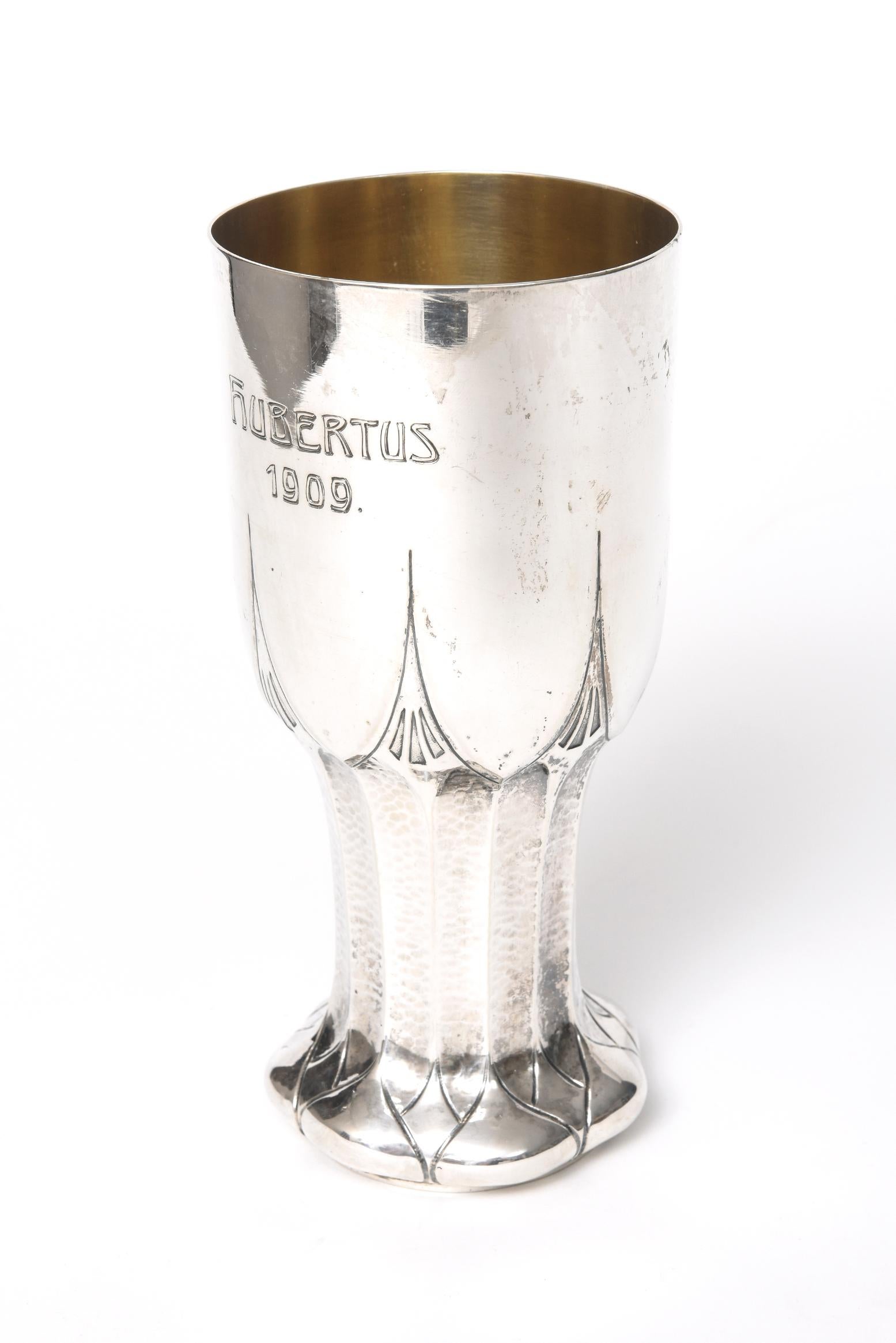 Stunning large arts and crafts 800 silver chalice featuring a hammered stem with a scalloped foot and geometric spikes going up the bowl of the cup. On the cup it is engraved Hubertus 1909. The bottom has German 800 silver hallmarks and is stamped