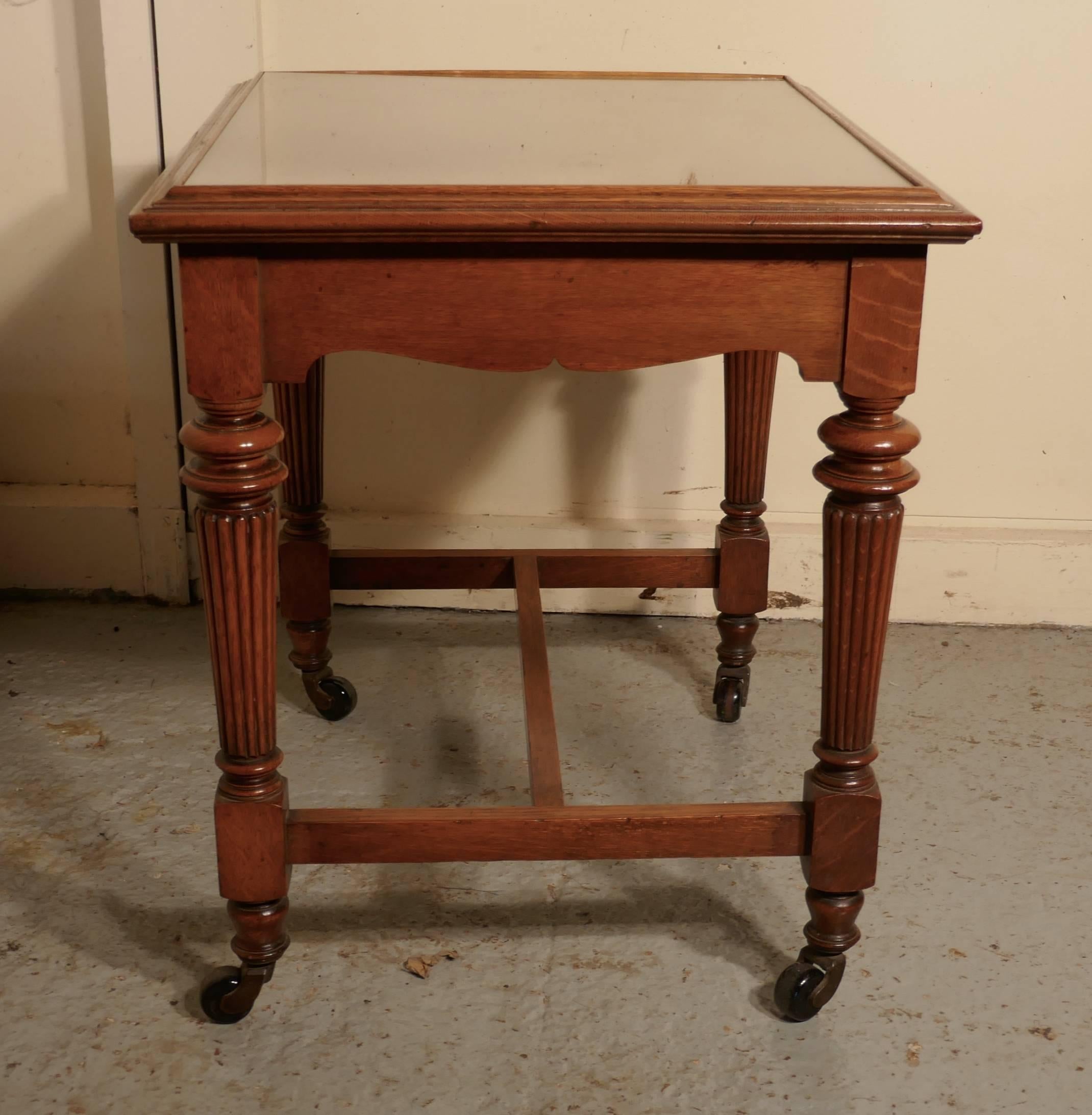 Arts & Crafts golden oak low occasional table.

This is a pretty and useful piece, the table is almost square and has an inset glass top, it stands on ceramic caters and has lovely turned and fluted legs with strong H-stretcher.
Measures: The