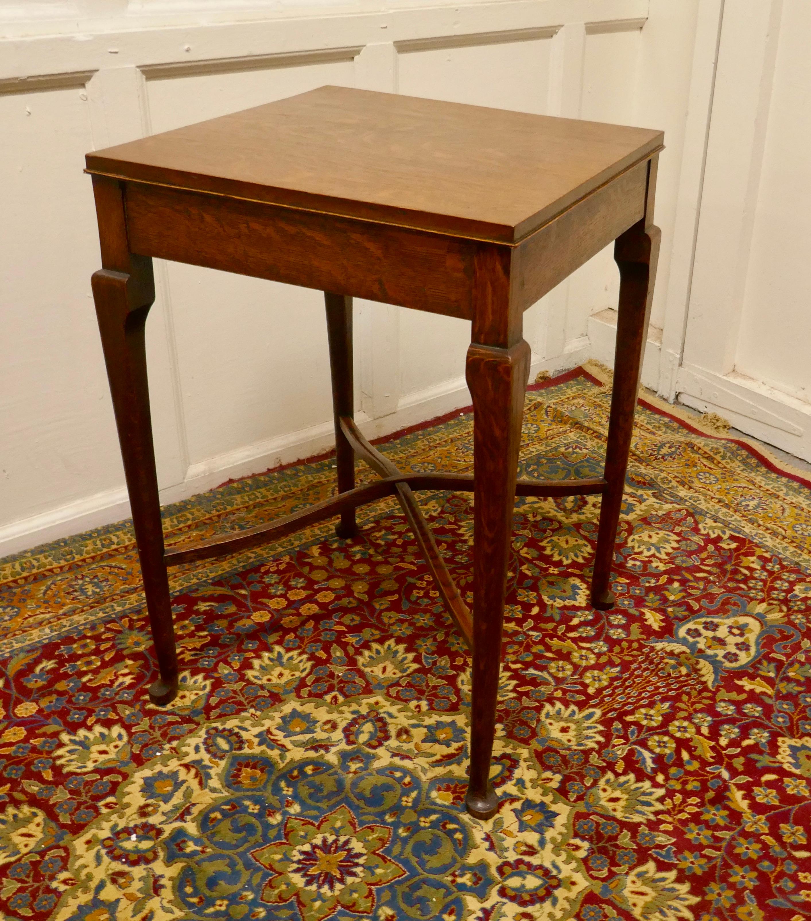 Arts & Crafts golden oak table.

A Lovely stylish table, the table legs are in a tapering pad foot style, these are joined with a sculptured X stretcher
The table is in good condition, there is a small chip on one corner.
It is 18” long, 18”