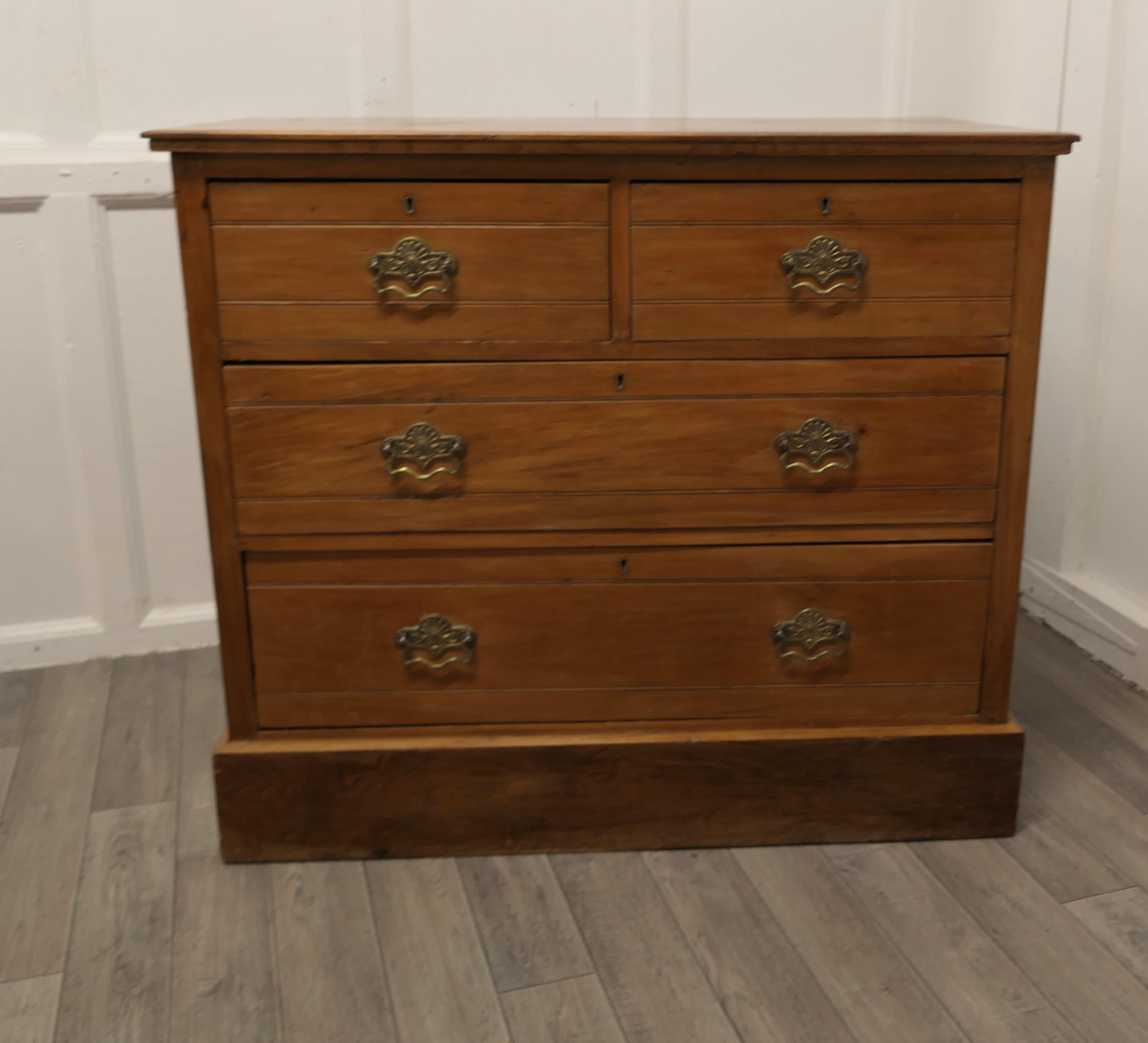 Arts and Crafts golden walnut chest of drawers

 This is a good solid chest, there are 2 short drawers over 2 graduated longdrawers with superb arts and crafts brass handles
The chest has a moulded edge to the top and a little carved decoration