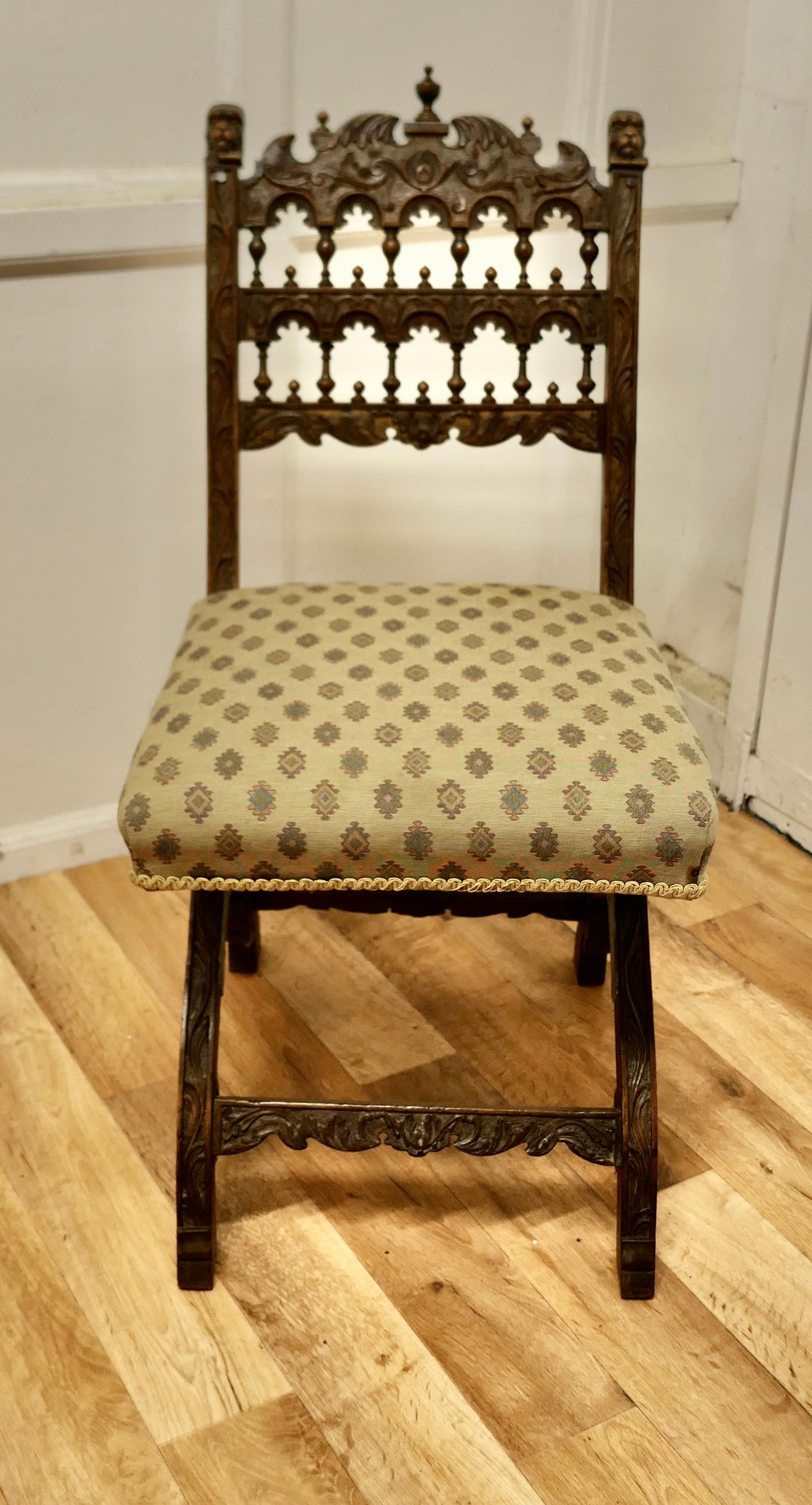 Arts and Crafts Gothic X Frame Carved Oak chair 

The chair has a very detailed carved and gilded frame with Lions faces on each side of the back. The chair is set on an X Frame which is also carved and it has old woven silk upholstery, the chair