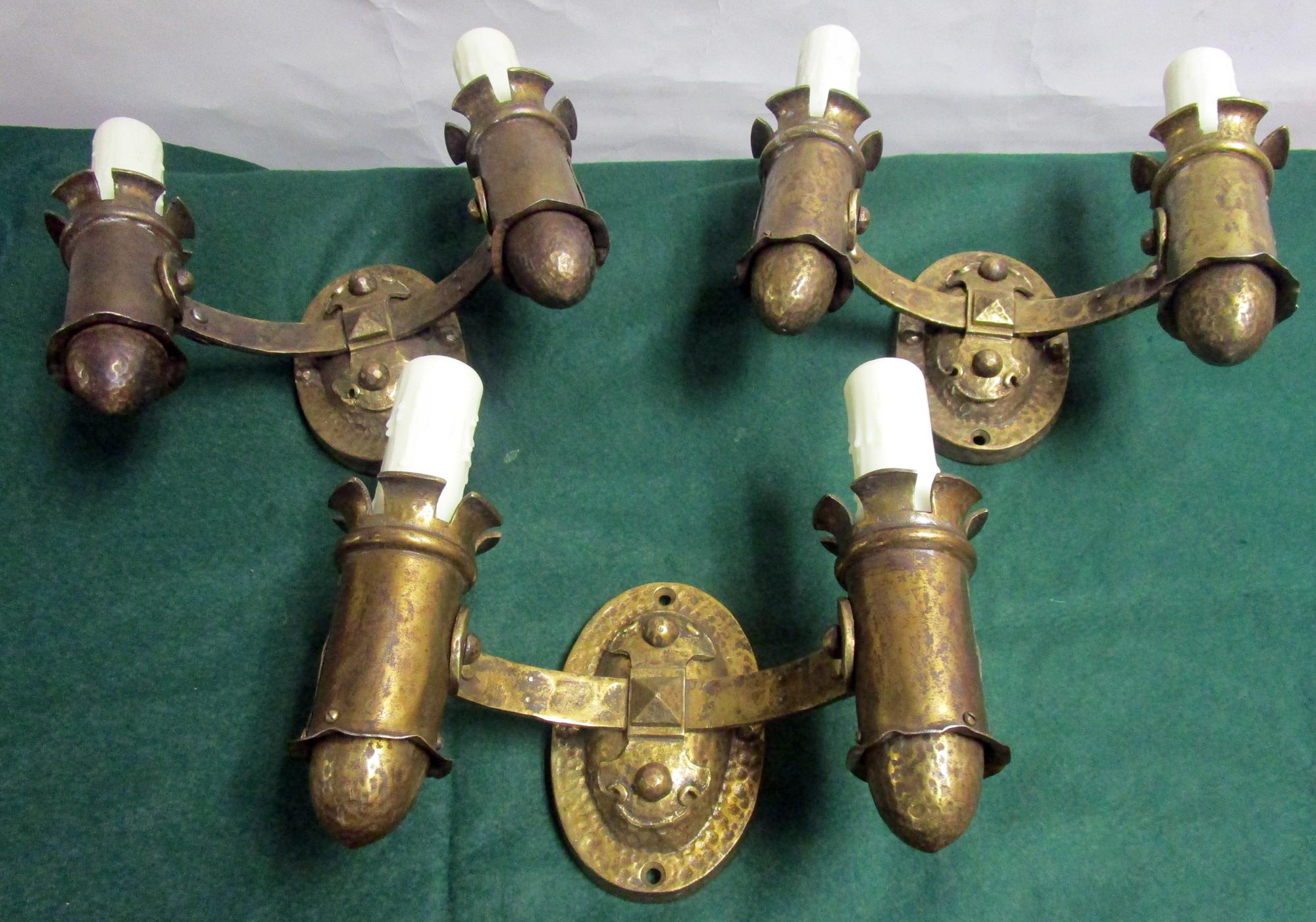Trois appliques à double bougie d'époque Arts & Crafts en laiton martelé dans un style plutôt gothique avec beaucoup de détails. L'étiquette porte la mention 