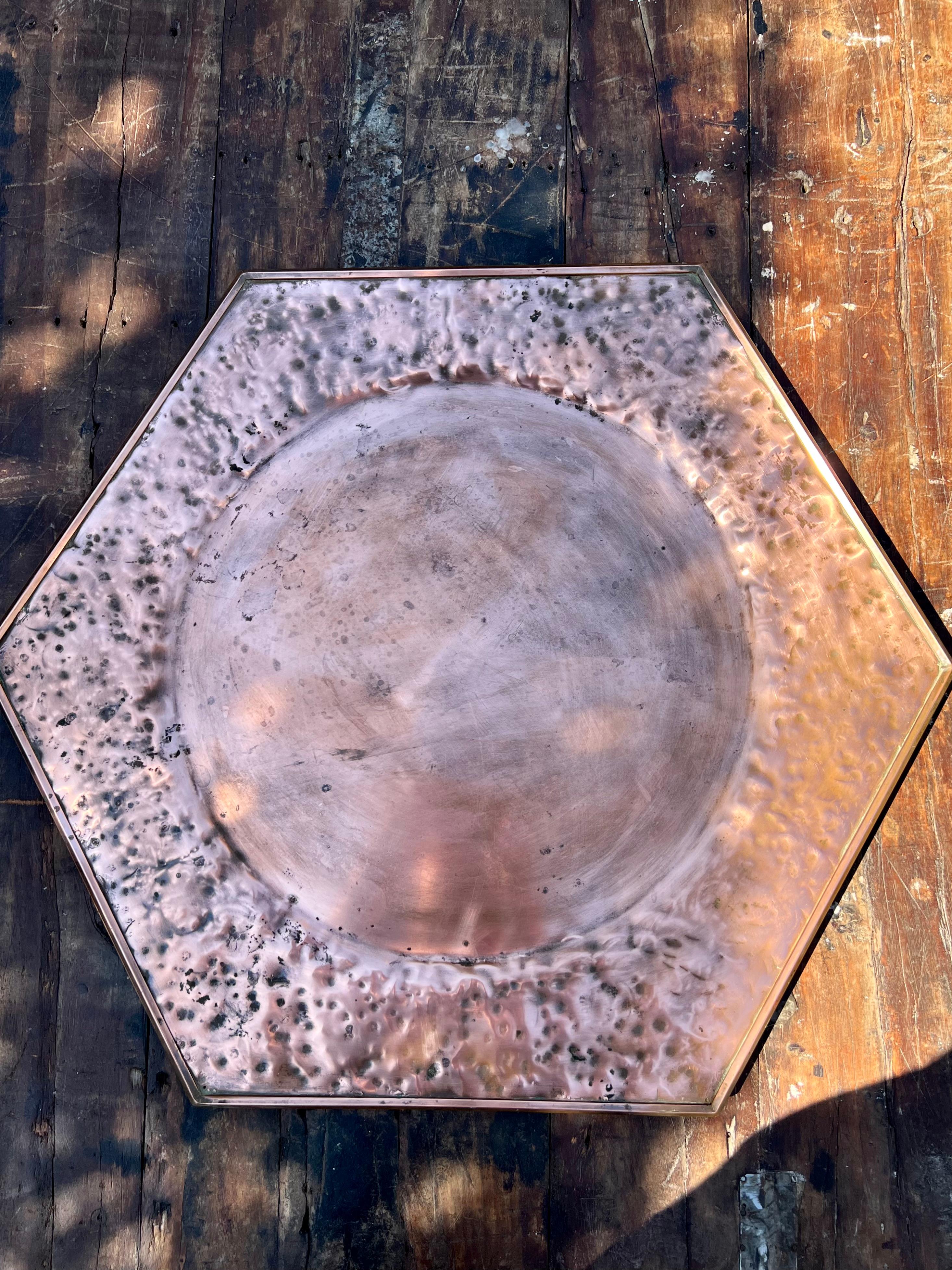 Stunning hammered copper tray in hexagon shape. 

In sacred geometry and ancient sagas the hexagon represents the potential for life. Because of its two interlocking triangles, the hexagon as a symbol often stands for harmony and balance. 

This