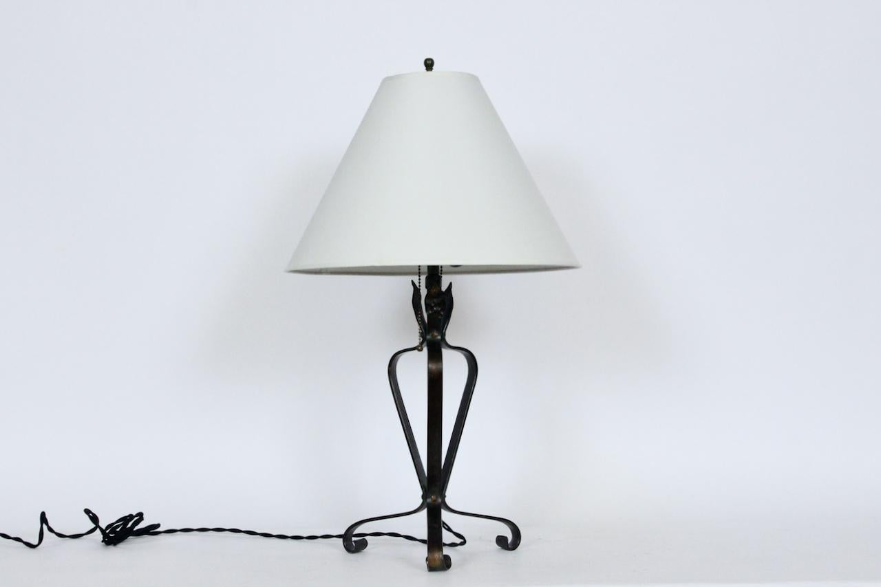 Early 20th century Electric handwrought Iron and Verdigris Brass Table Lamp. Featuring an open tri form in Iron and Brass with handwrought scroll feet. Square cap bolts to legs and bottom/top of column. Brass verdigris coloration evident on center