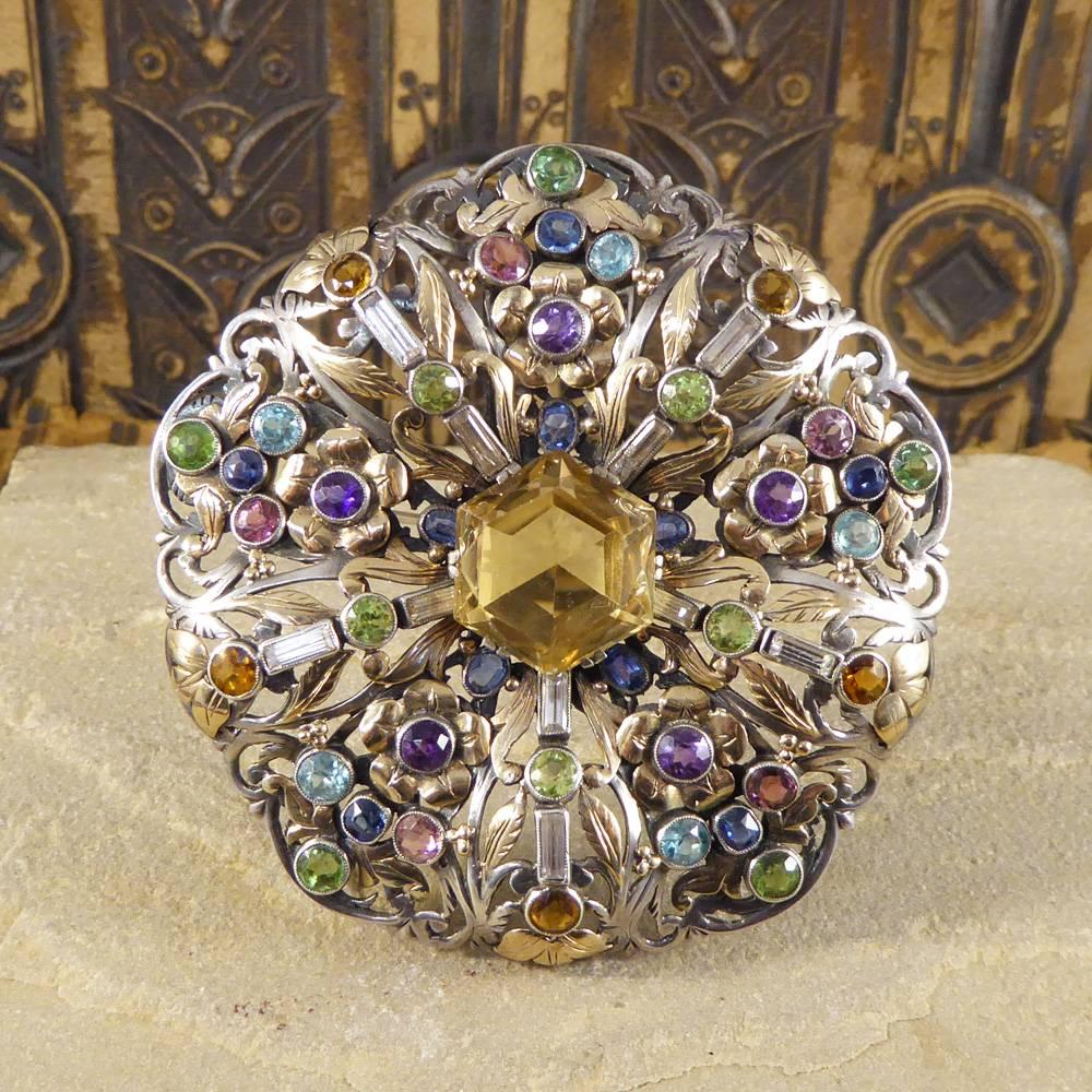 This stunning Multi-gem set brooch has been hand crafted in the Art and Crafts movement period. This was one of the most influential, profound and far-reaching movements of modern times. It began in Britain around the 1880s and quickly spread across