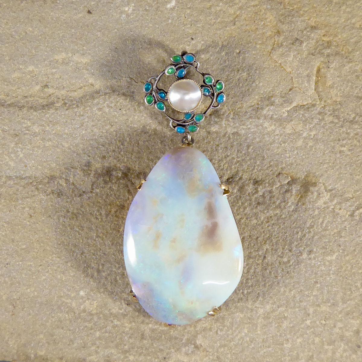A lovely Arts and Crafts hand crafted pendant with made with Yellow Gold and Silver setting. This gorgeous quality pendant holds a large Opal in a double claw setting, the setting has been made to shape around the unusual shaped Opal holding is
