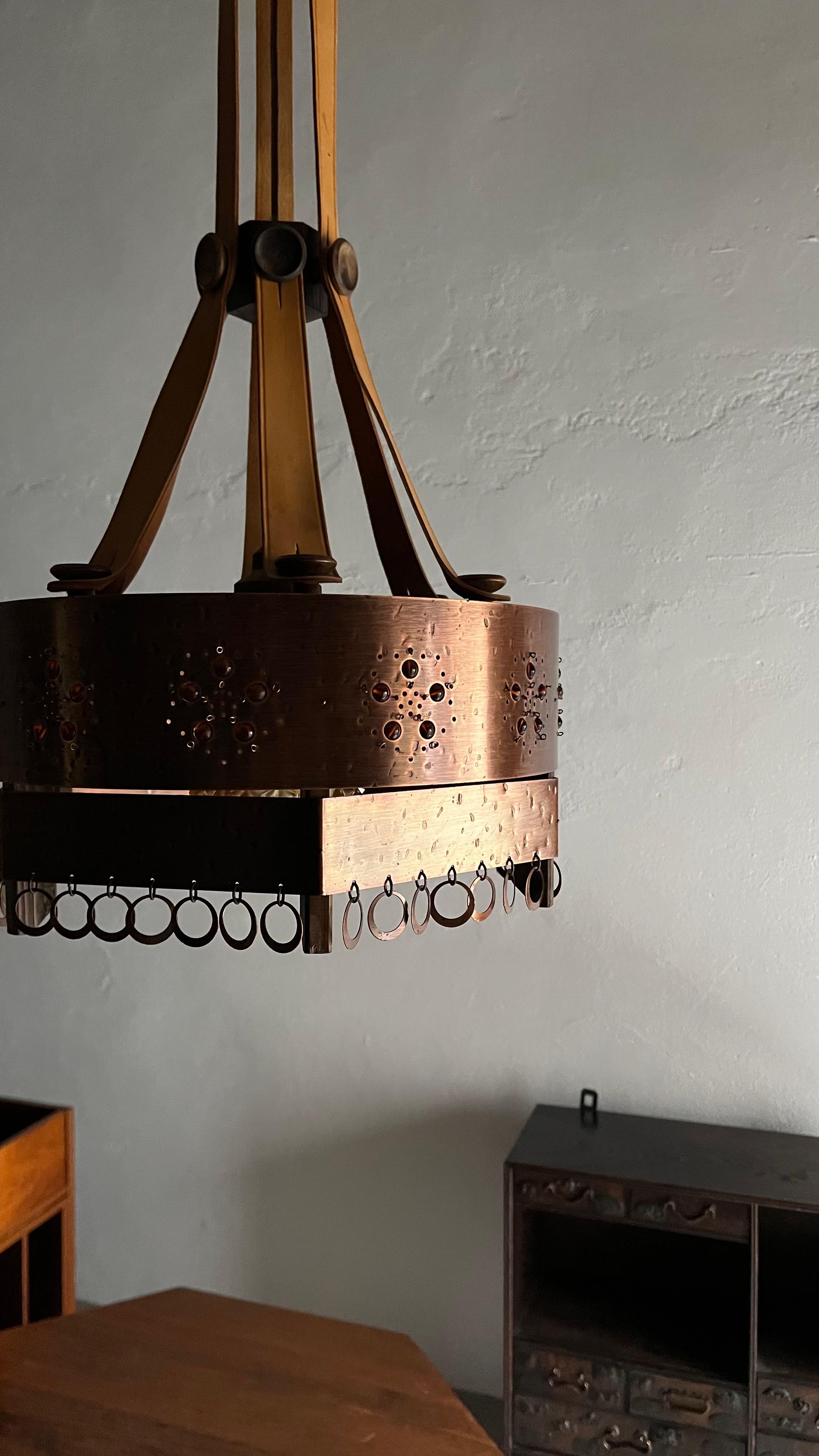 Vintage pendant lamp - copper shade, glass cup inside, leather straps, wooden upper details.

Additional information:
Country of manufacture: Sweden
Period: 1920s
Dimensions: H(shade) 18 cm, H(total+ceiling cup) 126+20 cm, D(shade) 38 cm
Condition: