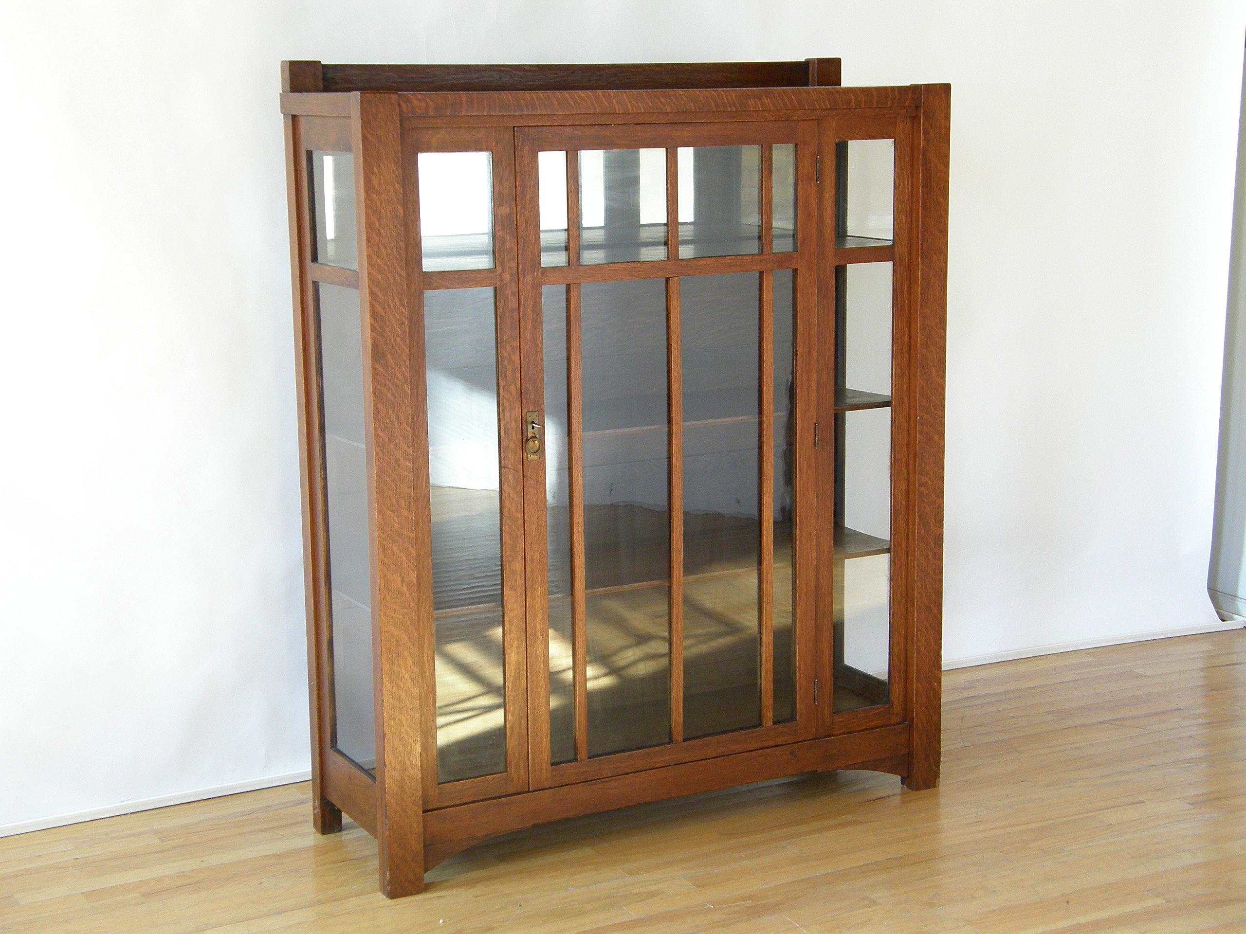 This handsome, Mission oak china cabinet or bookcase has a Classic Arts & Crafts style. The thick corner supports continue down to form the legs, and the back two extend above the top and flank a back panel to provide a more finished look to the