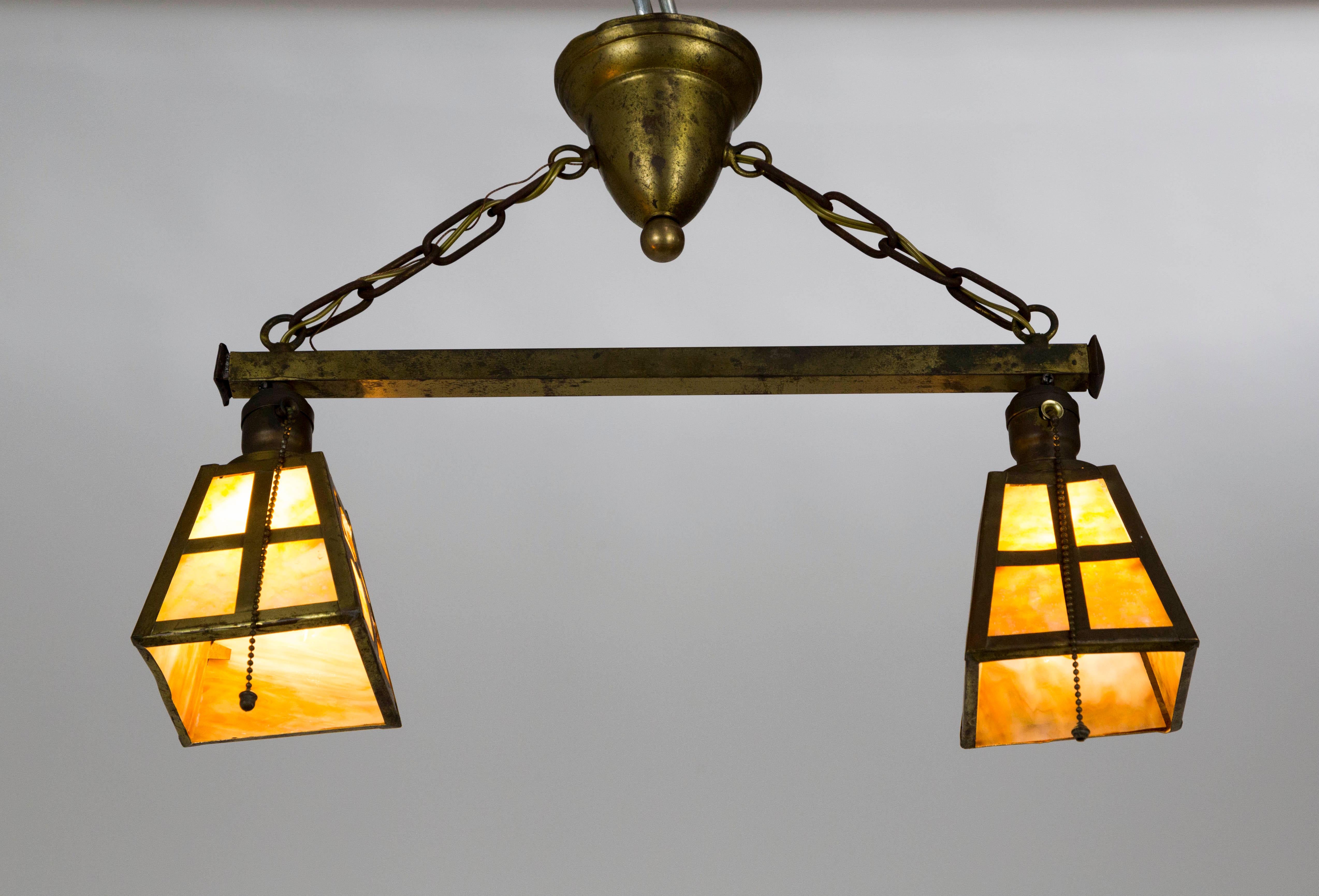 Con una splendida patina e un autentico vetro di scoria color ambra, questo apparecchio emana calore ed emana un classico utilitarismo Art & Crafts.  Il vetro scoria si illumina in modo ambizioso quando viene illuminato e i dettagli in ottone sono