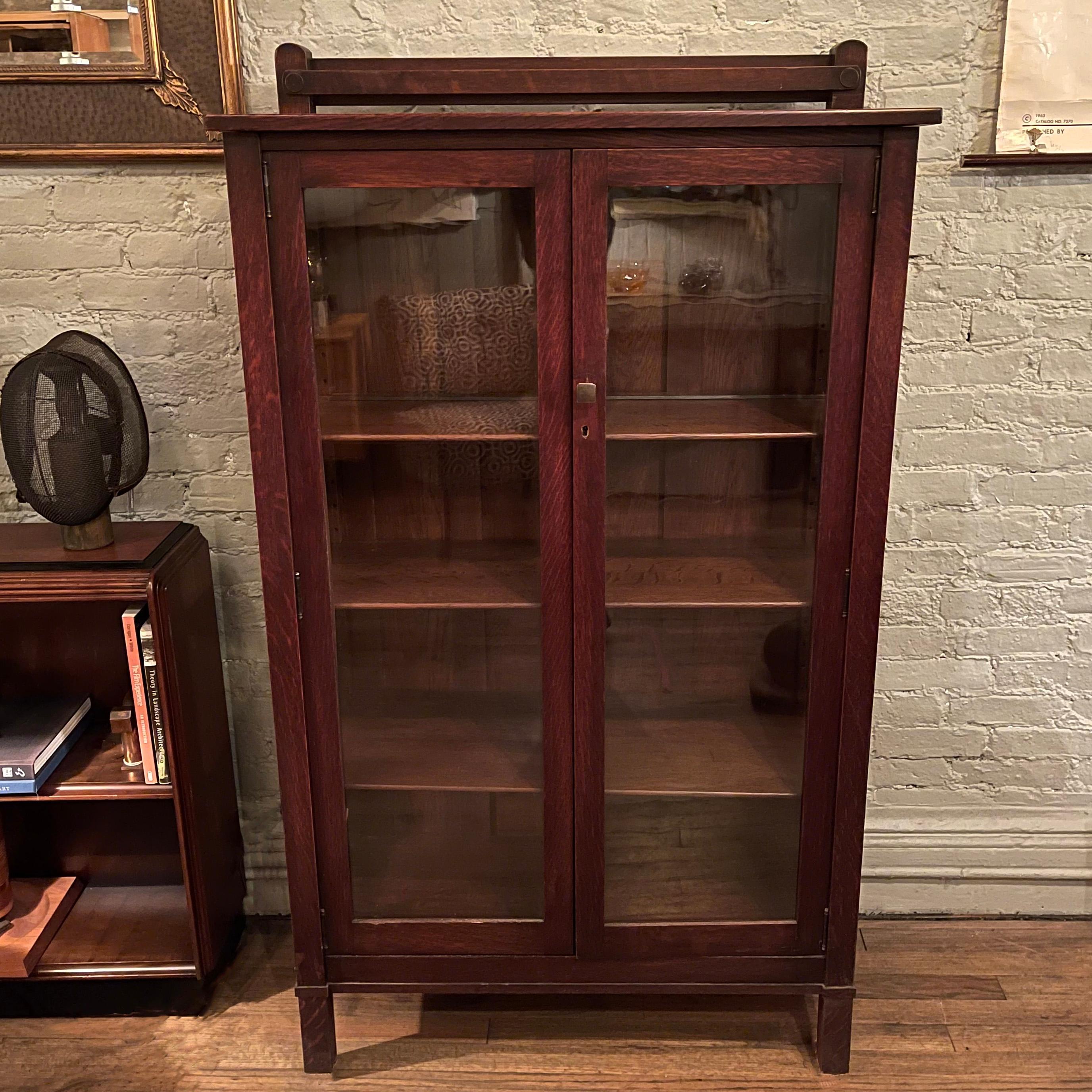 Early 20th century, oak, bookcase, display cabinet features glass on 3 sides and 3 adjustable wood shelves. The height to the top of the cabinet is 55.25 inches, the overall height is 58.5 inches. The interior depth is 11.5 inches.