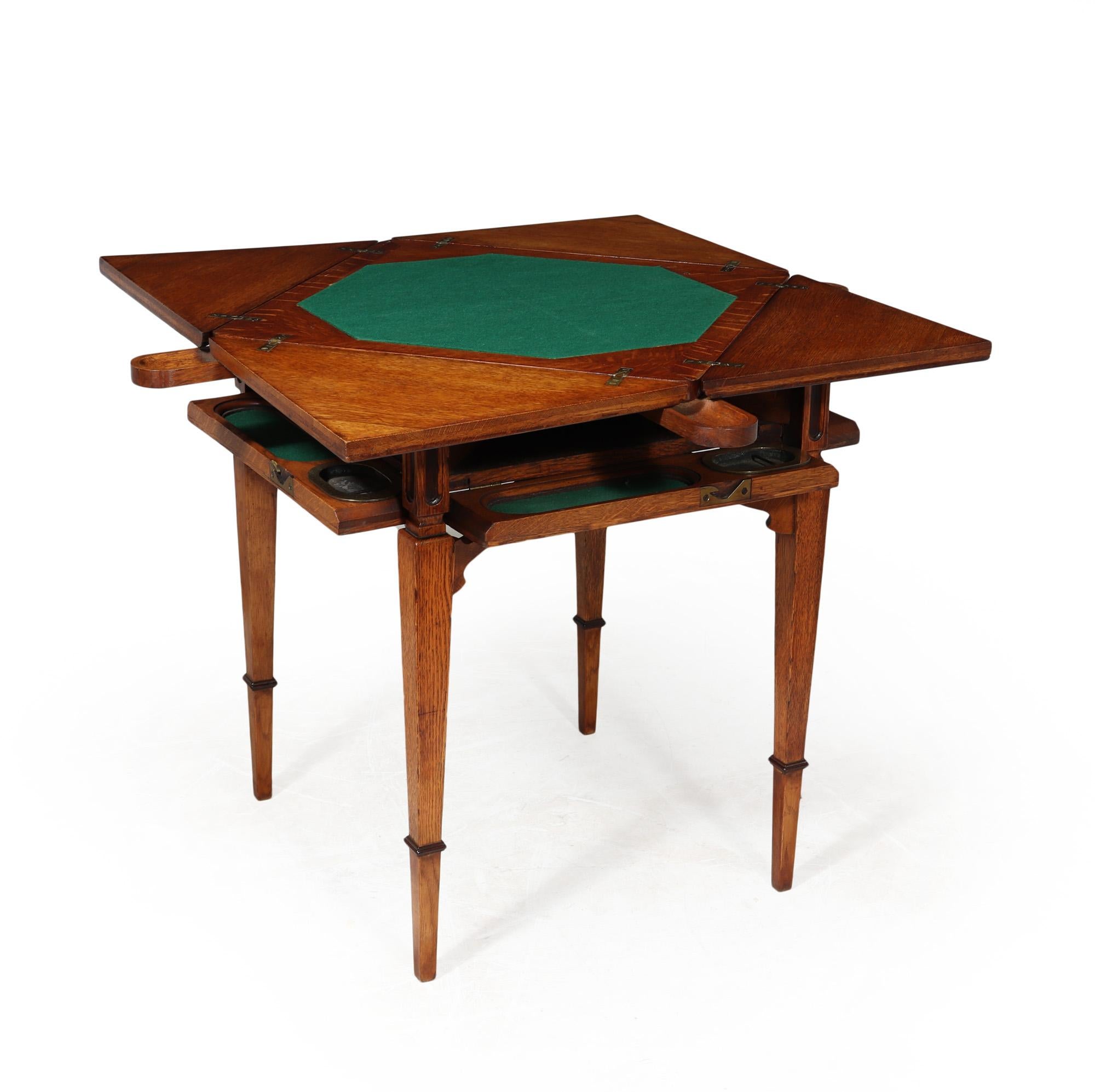 An excellent quality solid oak envelope card table c1890, 4 hinged flaps that open to reveal a central baize playing area four pull out coin holders and below are drop down players area and original brass ashtrays, I have never seen one with this