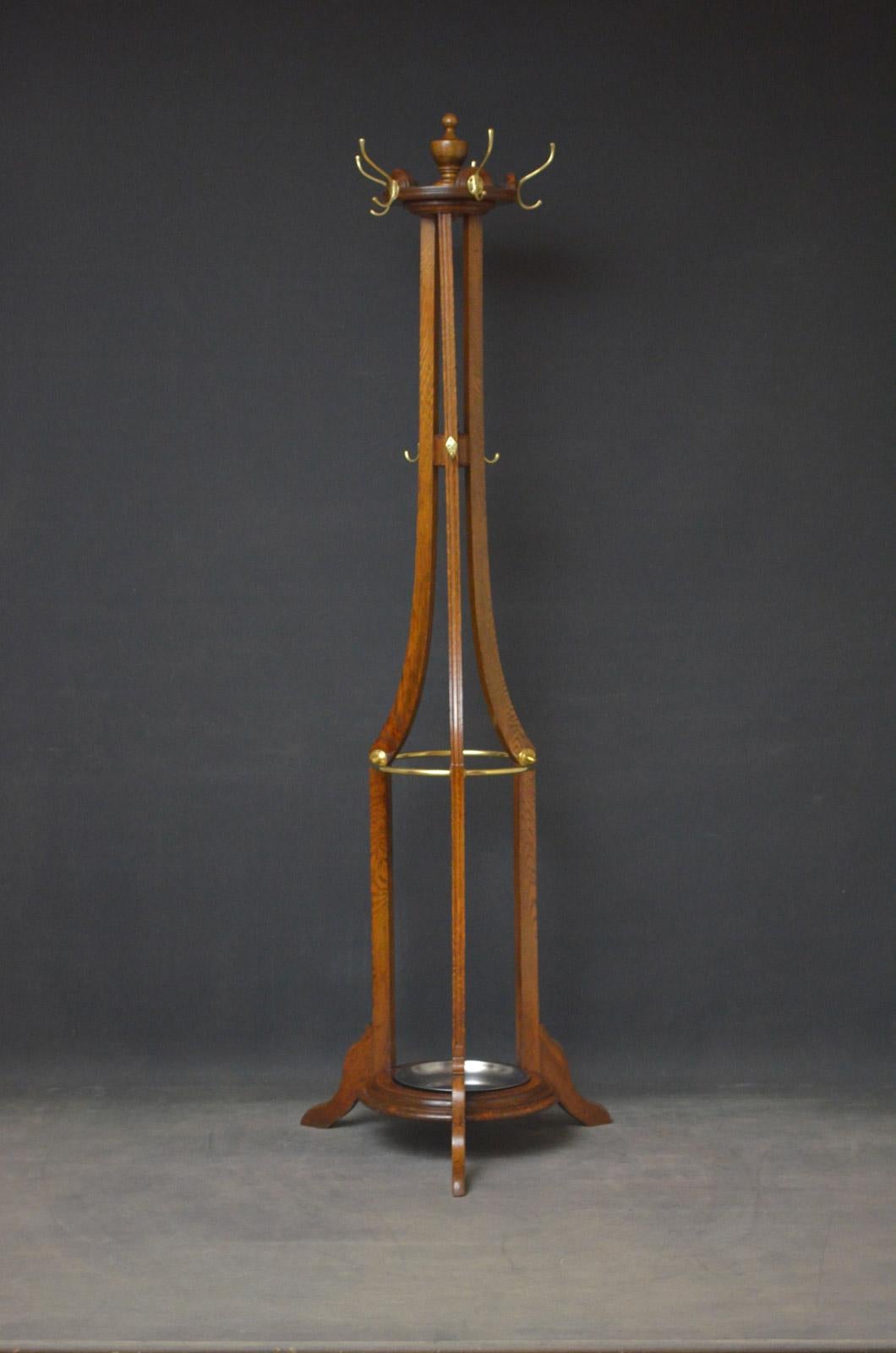 Sn4592 Arts & Crafts oak hall Stand, having original brass hat and coat hangers on revolving platform and 3 reeded supports terminating in 3 legs united by circular base with removable drip tray (replacement). This antique coat Stand retains its