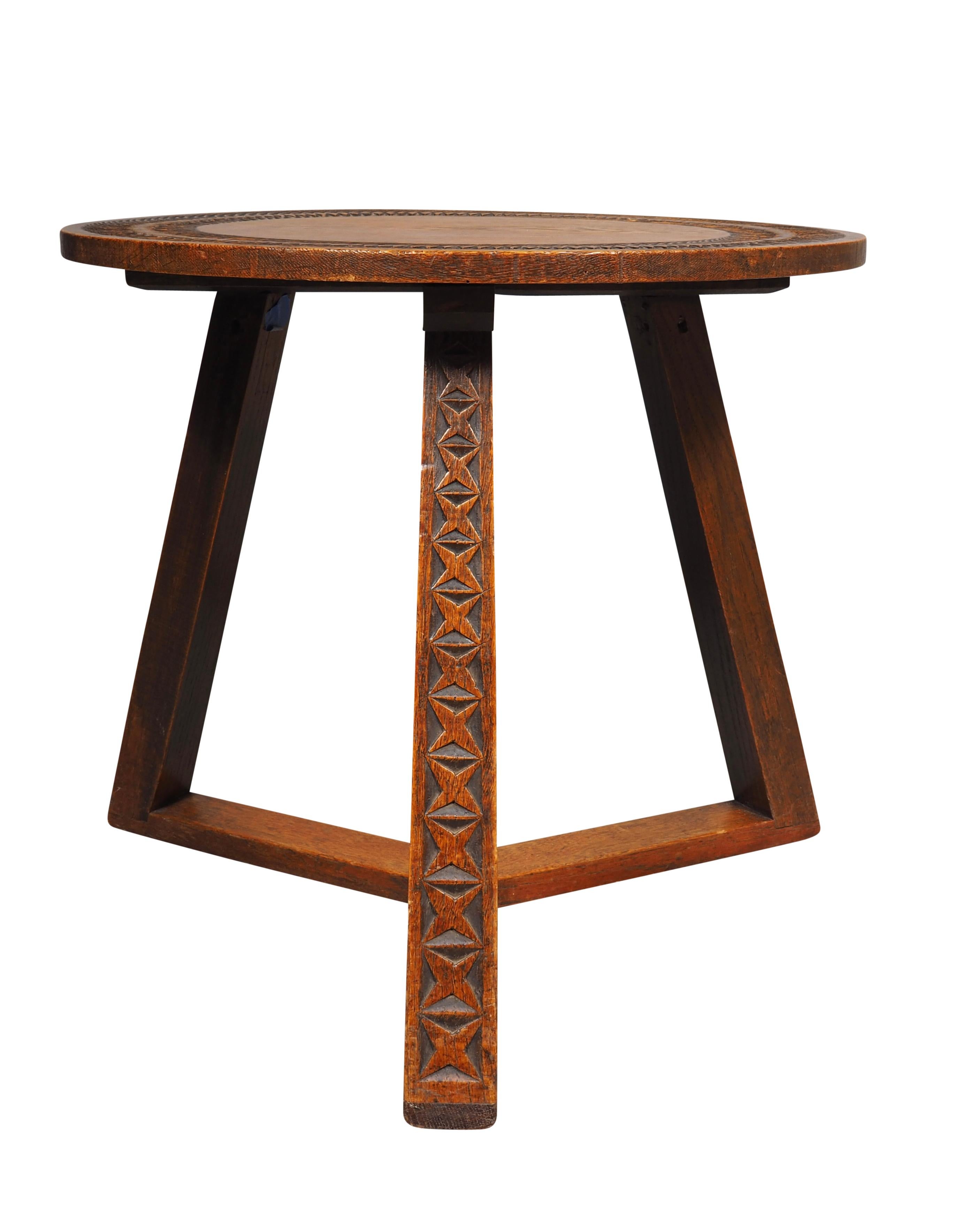 With a Scandinavian twist this table has a round top with carved concentric design. The base with three splayed legs with carved detail and stretcher.