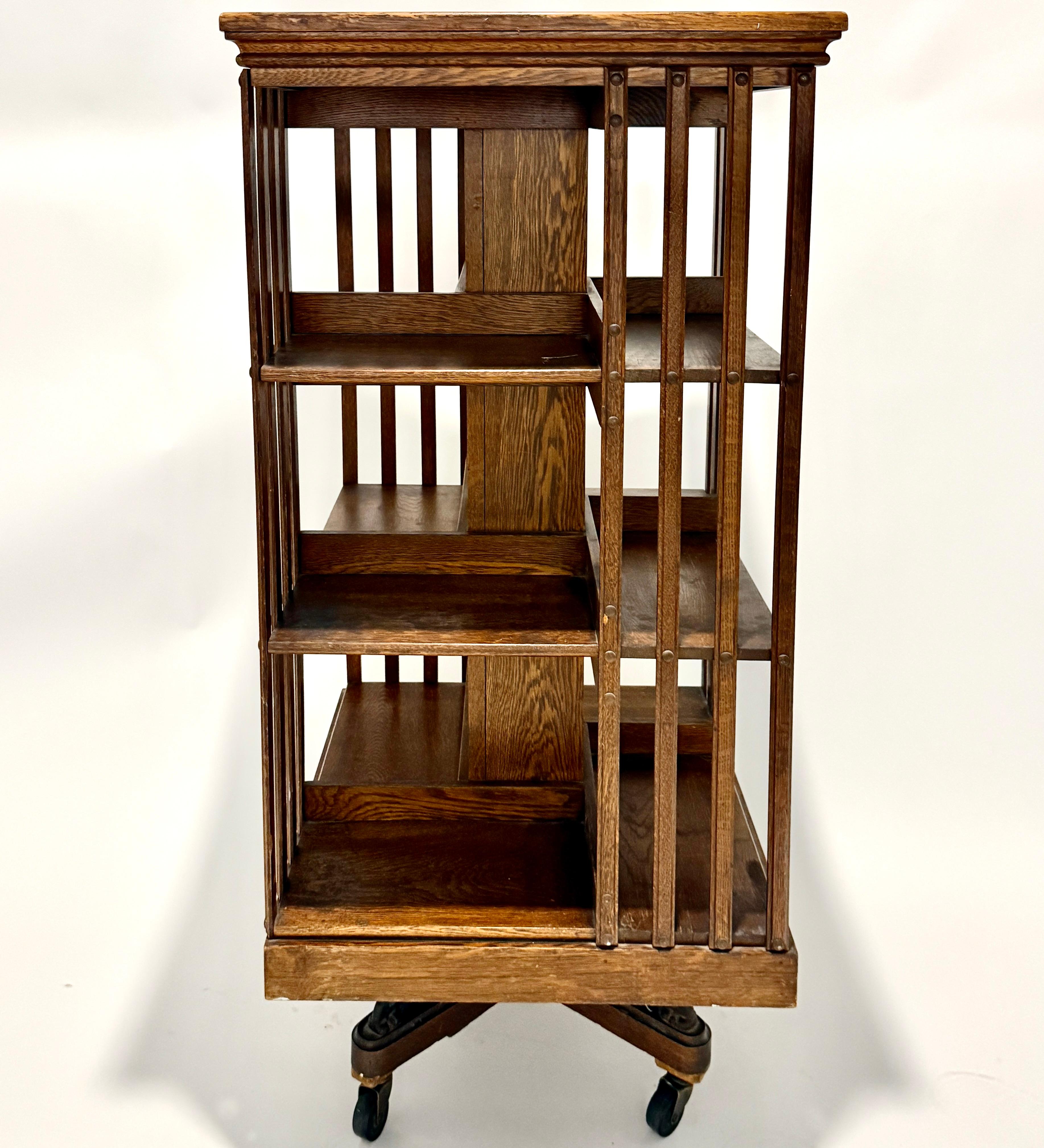 An exceptional Arts and Crafts period revolving bookcase by the renowned American maker Danner, crafted circa 1900–1915. Constructed from solid quarter-sawn oak, this finely made piece features a two-tier design with open shelving on all four sides,