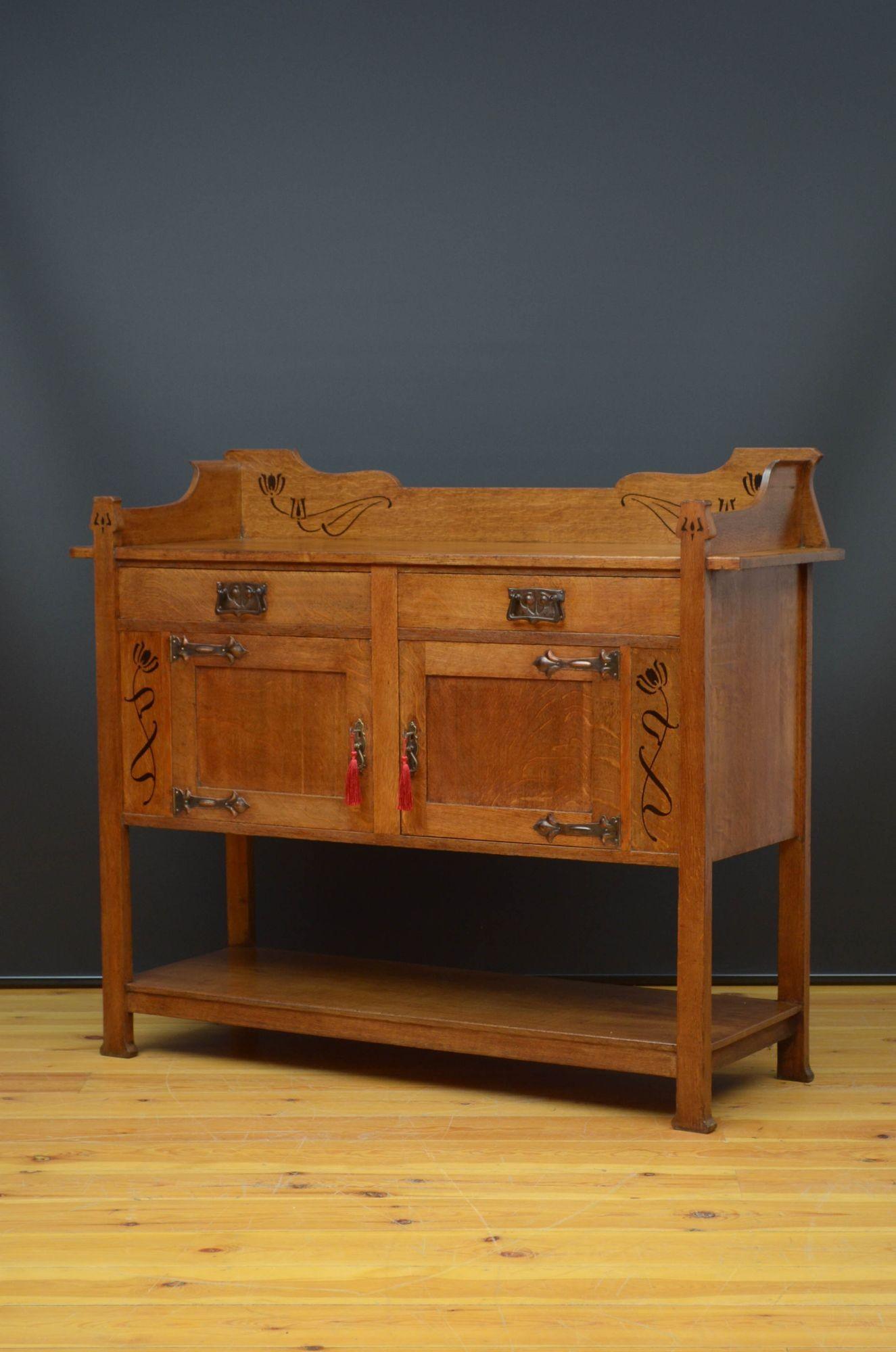 Sn5431 Stylish Arts and Crafts oak sideboard, having shaped and inlaid gallery to the top above two frieze drawers fitted with original handles and two panelled cupboard doors also fitted with original handles, working locks with keys and decorative