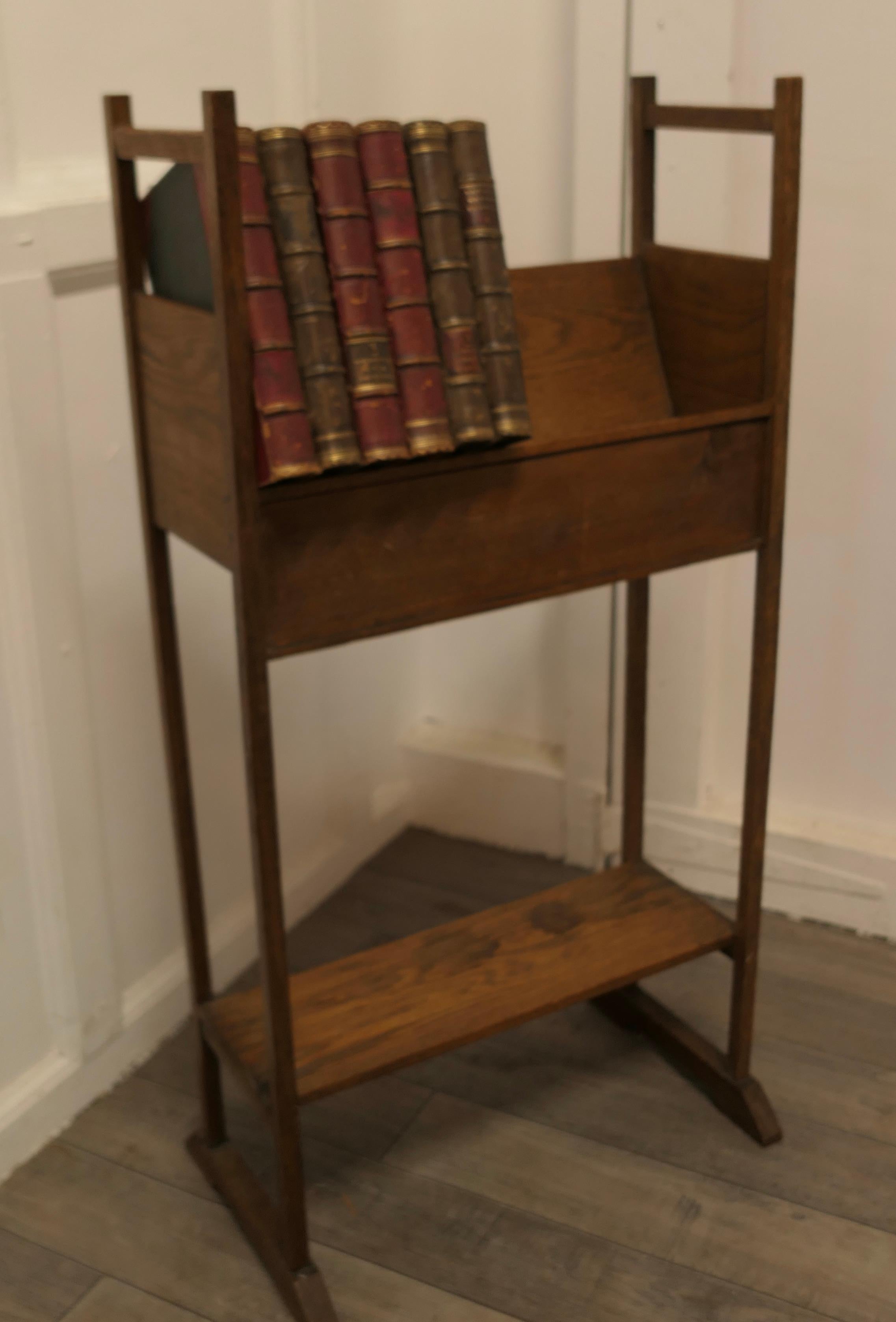 Arts & Crafts Oak Slope-Shelf Bookcase with Undertier.

This small Oak bookcase has an open slope-shelf at the top and a flat shelf at the bottom 
The shelf has lifting handles at the top and would work well in a small space where a bookshelf is