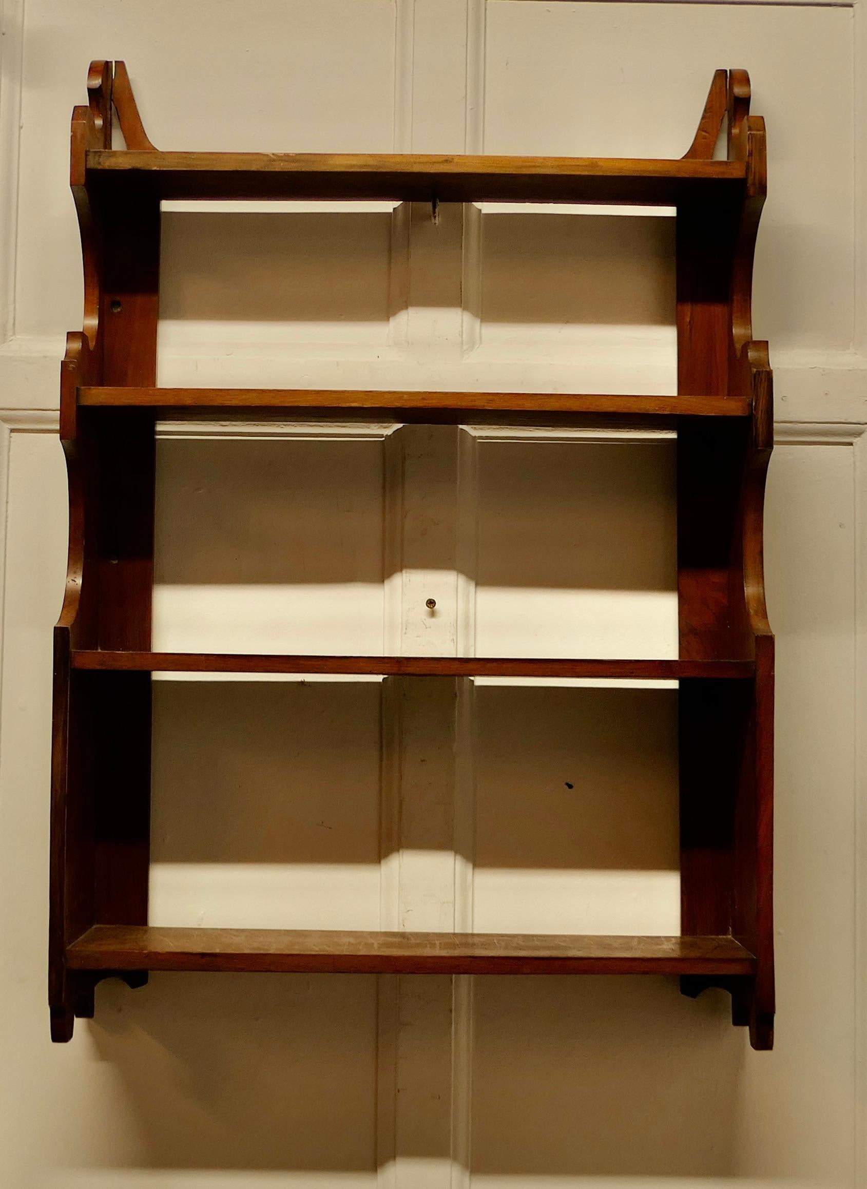 Arts and Crafts Open Front Wallhanging Walnut Bookshelf

This little bookcase has 4 open shelves and a carved waterfall decoration at each side 
The bookcase is in good attractive and sturdy condition and would work very well in your Living room,