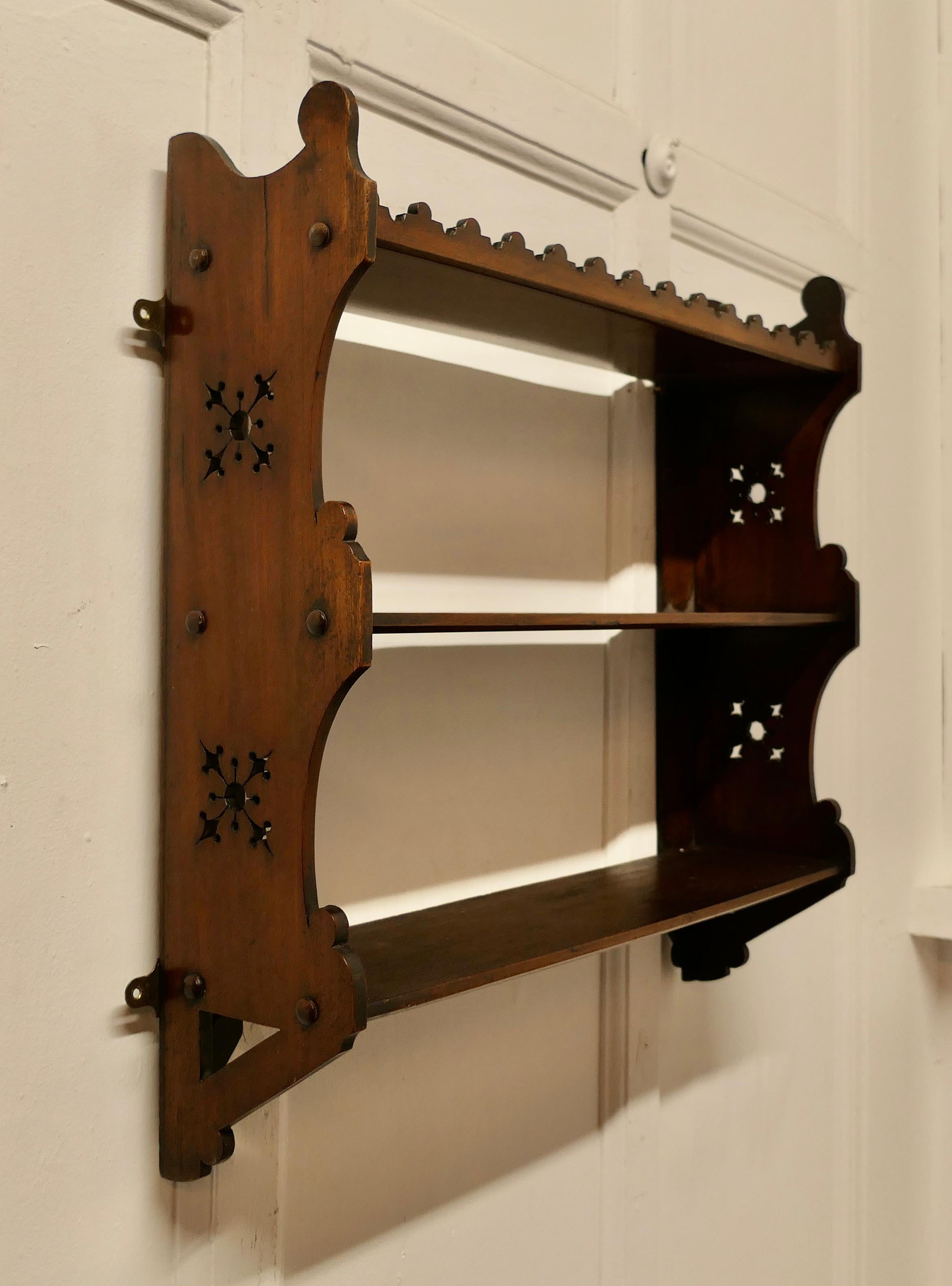 Arts and Crafts Open Front Wallhanging Walnut Bookshelf

This little bookcase has 3 open shelves and a carved scalloped shape at each side 
The bookcase suitable for wall hanging or it will stand on a floor, it is in good attractive and sturdy