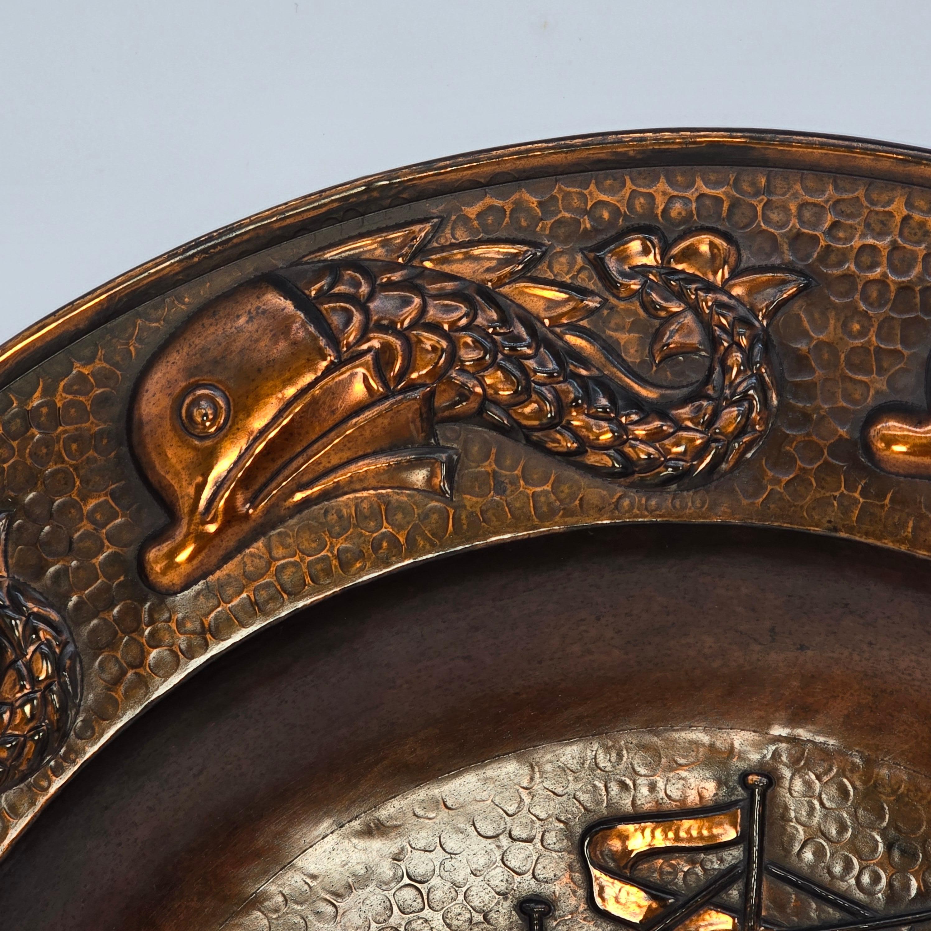 This large and highly decorative charger was made at the Cornish Arts and Crafts Copper Works, J. F. Poole of Hayle.
They operated at the same time as the Newlyn School, late 19th early 20th century producing similar hand crafted decorative copper