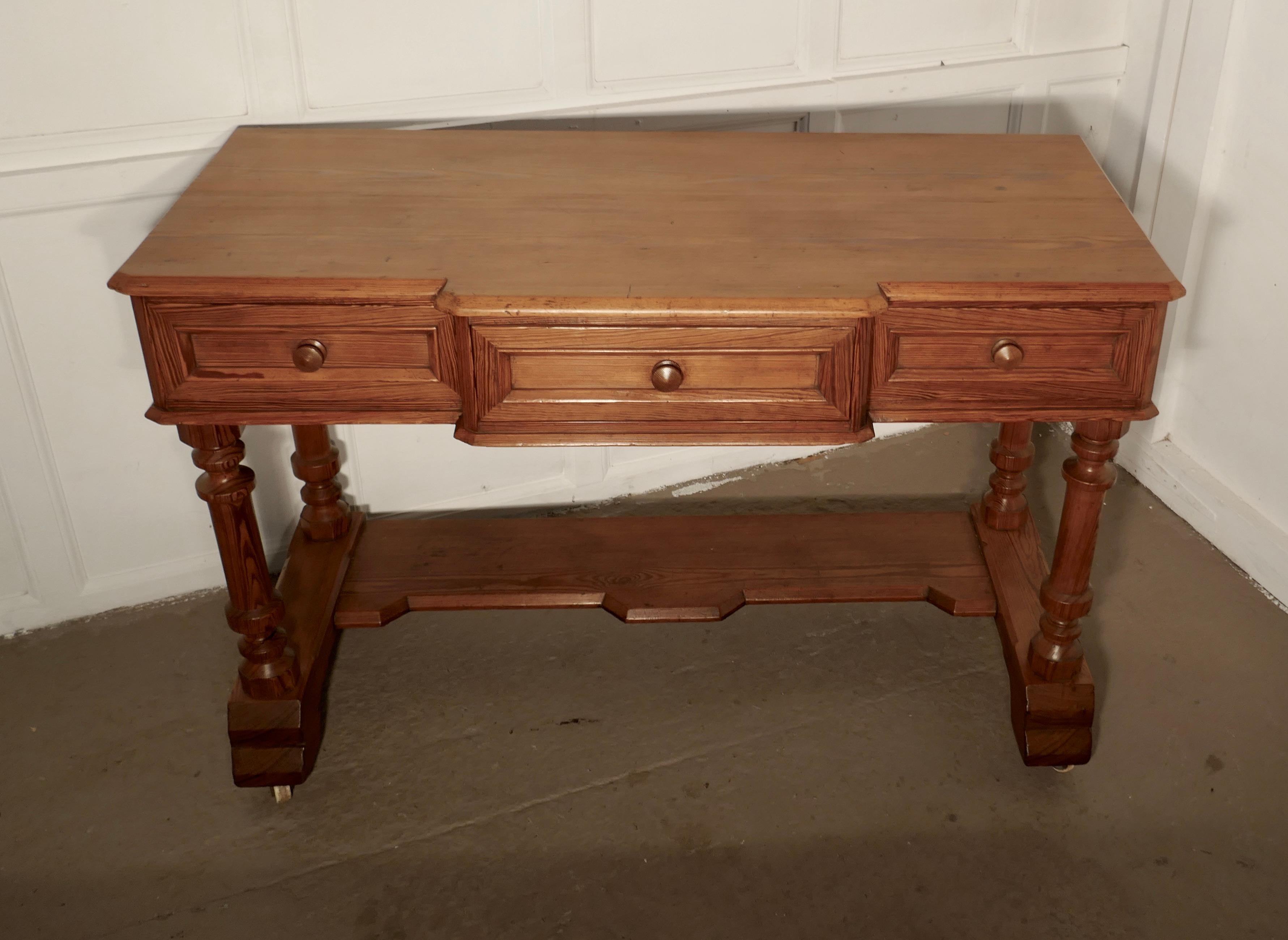 Arts & Crafts pitch pine writing table
 
A good heavy quality pitch pine side table or writing table in the Arts & Crafts style
There are 3 drawers along the break side, they have turned pitch pine knobs
The desk has a shaped edge to the top and