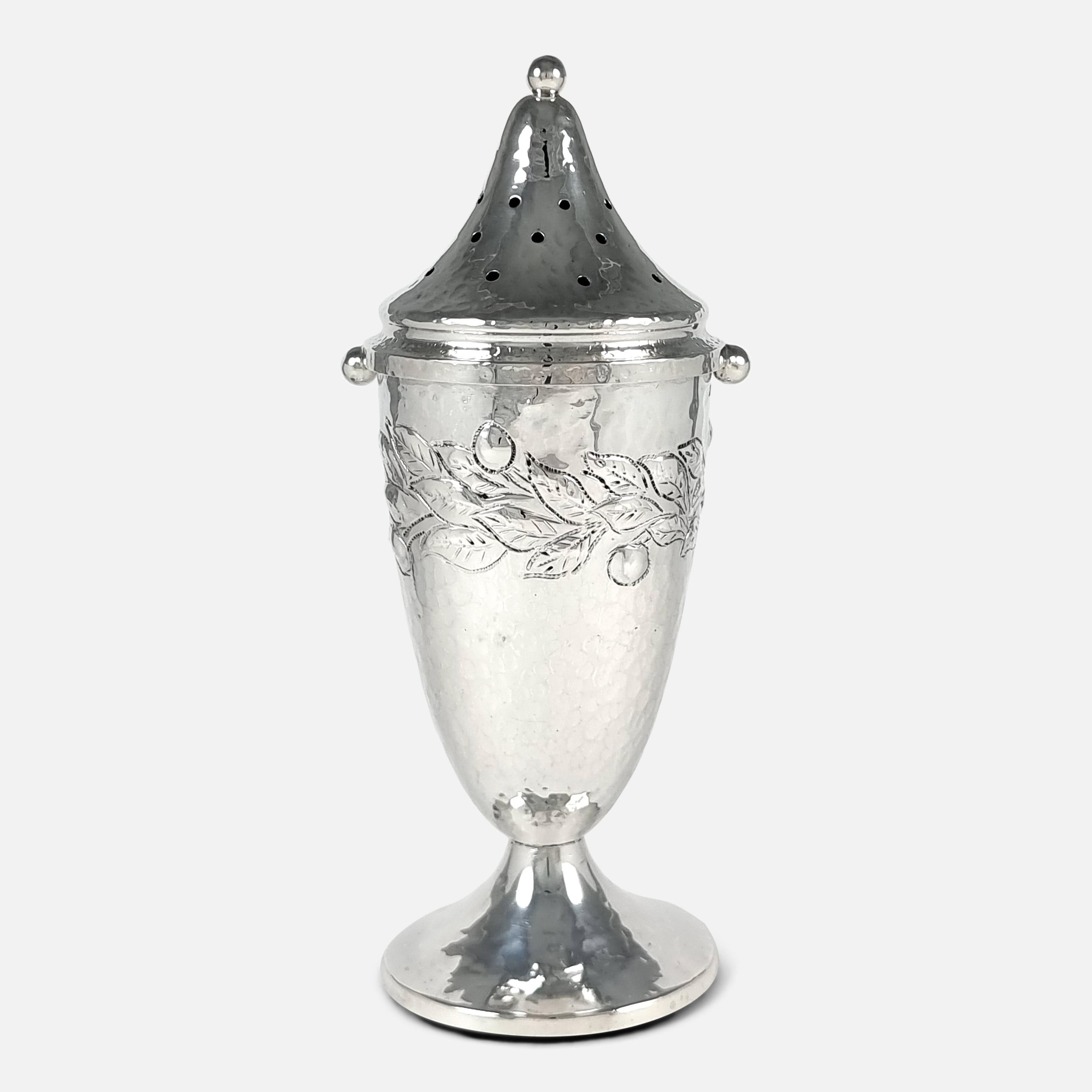 An Arts and Crafts sterling silver sugar caster. The sugar caster is of tapering circular form, spot-hammered decoration, embossed with a foliate girdle, bayonet fitting domed pierced cover with a ball finial, on a spreading circular foot, and