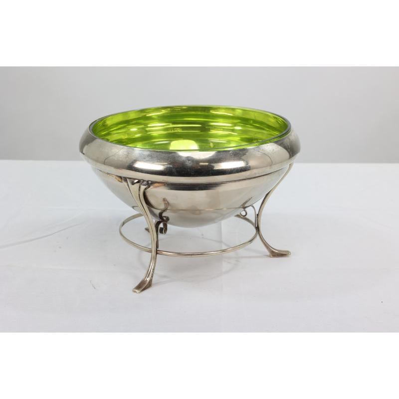 WAS Benson style. An Arts & Crafts silver-plate centerpiece with conical shaped bowl raised on three stylized legs with little pad feet, retaining the original green glass liner.
