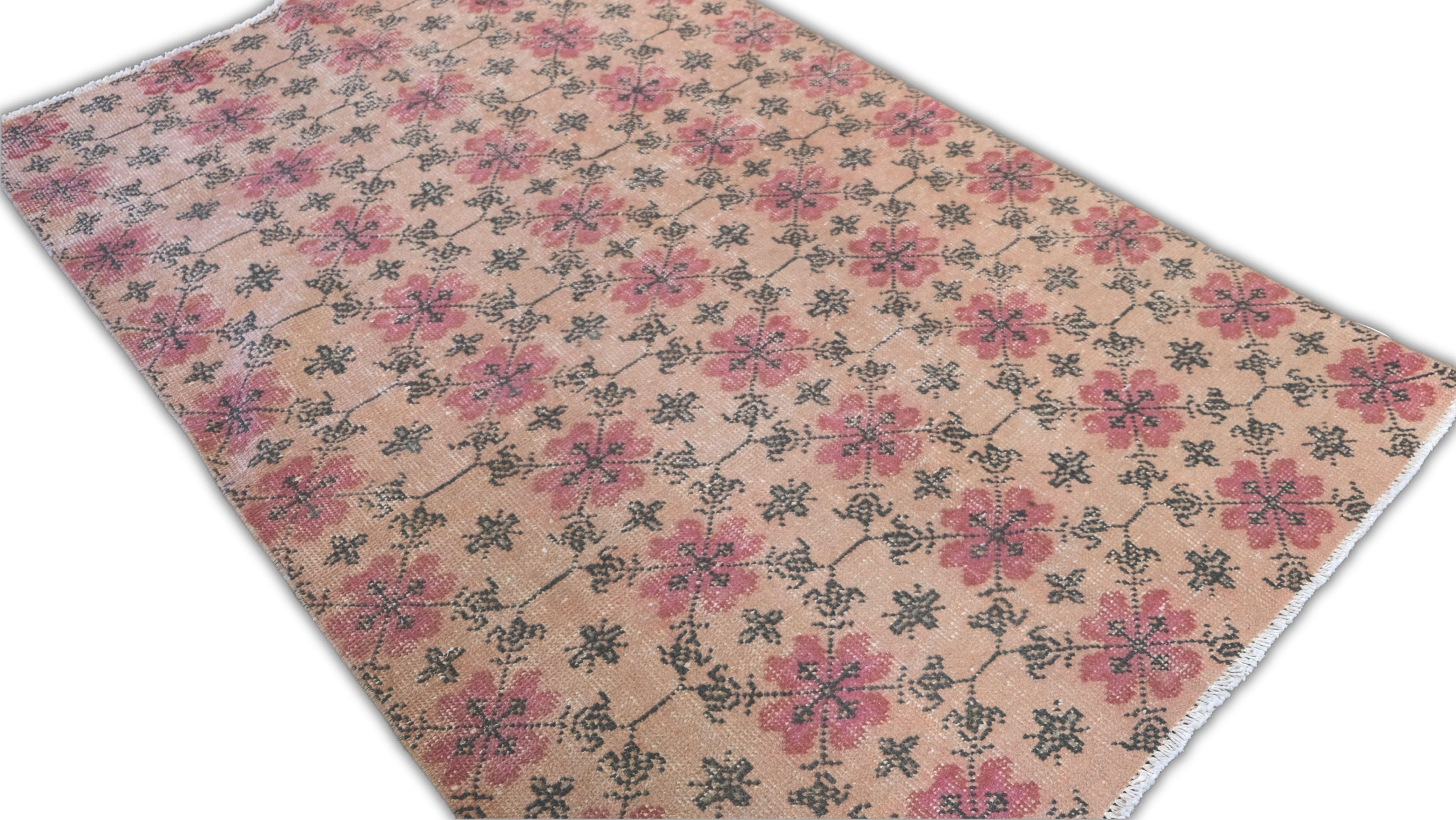 Ce tapis en laine noué à la main présente un élégant motif géométrique floral, alliant un design traditionnel à une esthétique moderne et vieillie. Les motifs floraux délicats et répétitifs en rouge et noir doux se détachent sur un fond beige chaud,