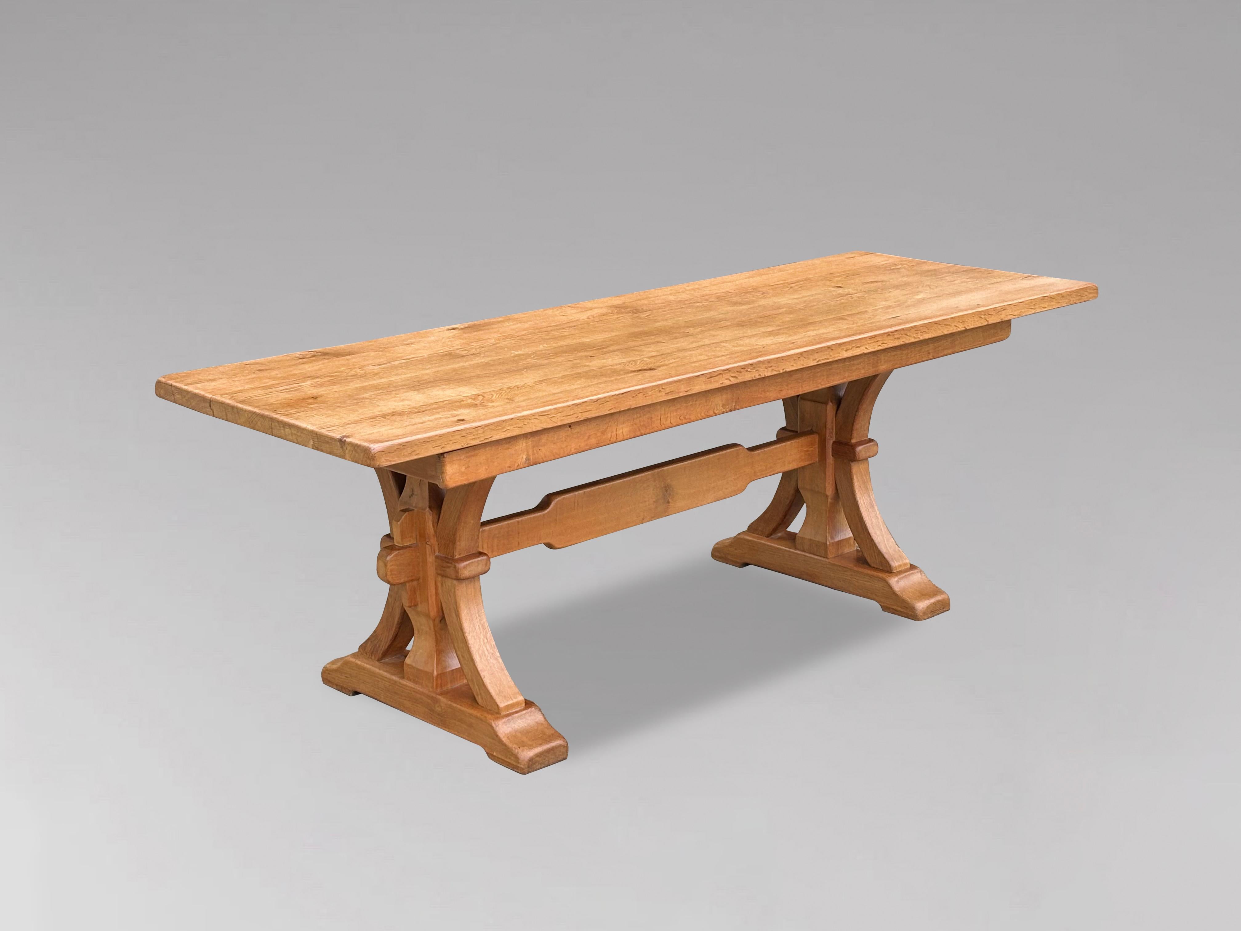 A mid 20th century solid English thick light oak refectory dining table in the Arts & Crafts manner. The beautifully rectangular figured thick oak 4 planked top, supported over a trestle base with peg construction and high central stretcher. A great