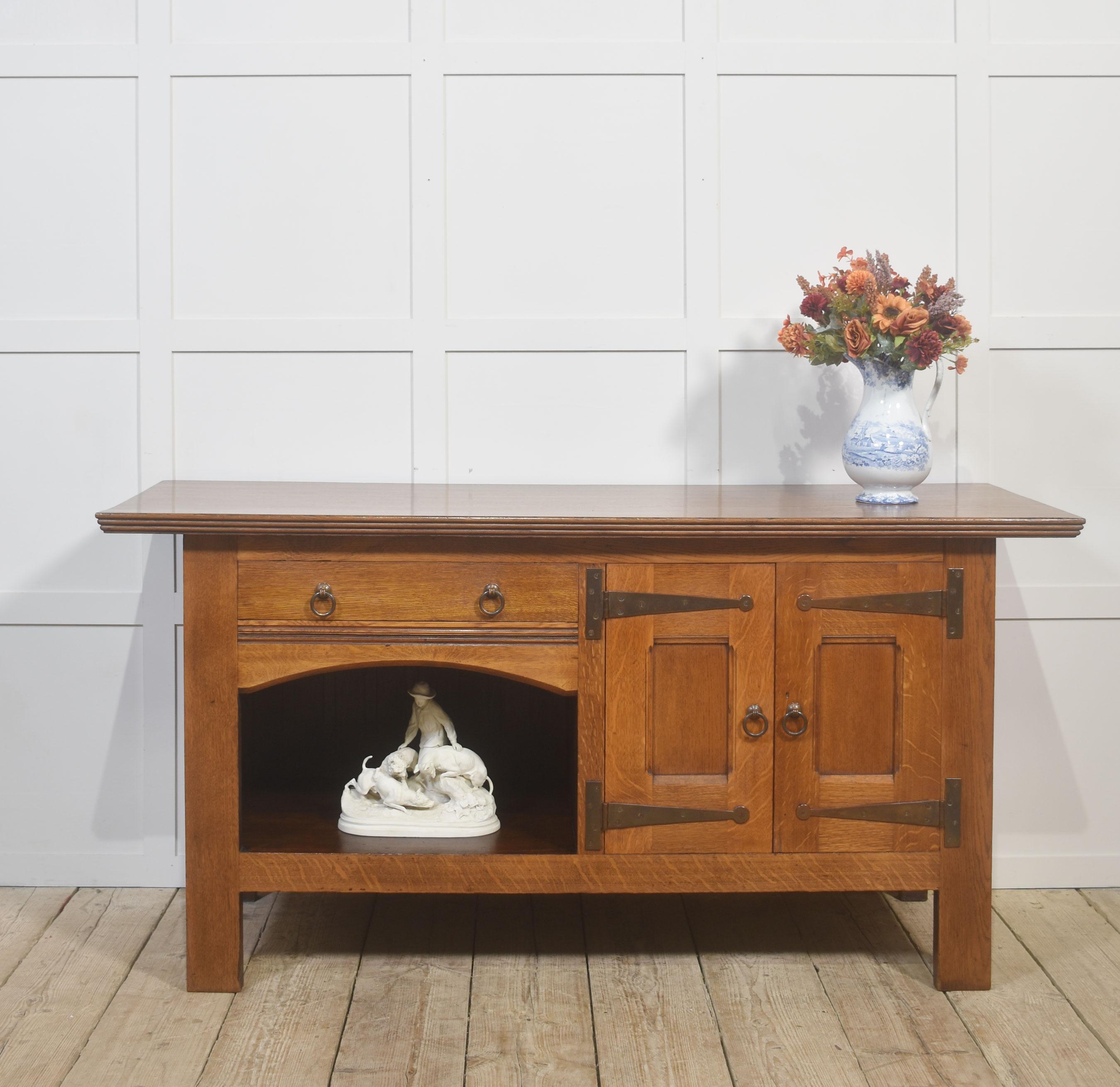 This solid oak sideboard is an excellent example of the Arts 
Crafts tradition, built with an emphasis on honest materials and straightforward craftsmanship. The broad overhanging top, finished in a warm medium oak, highlights the natural