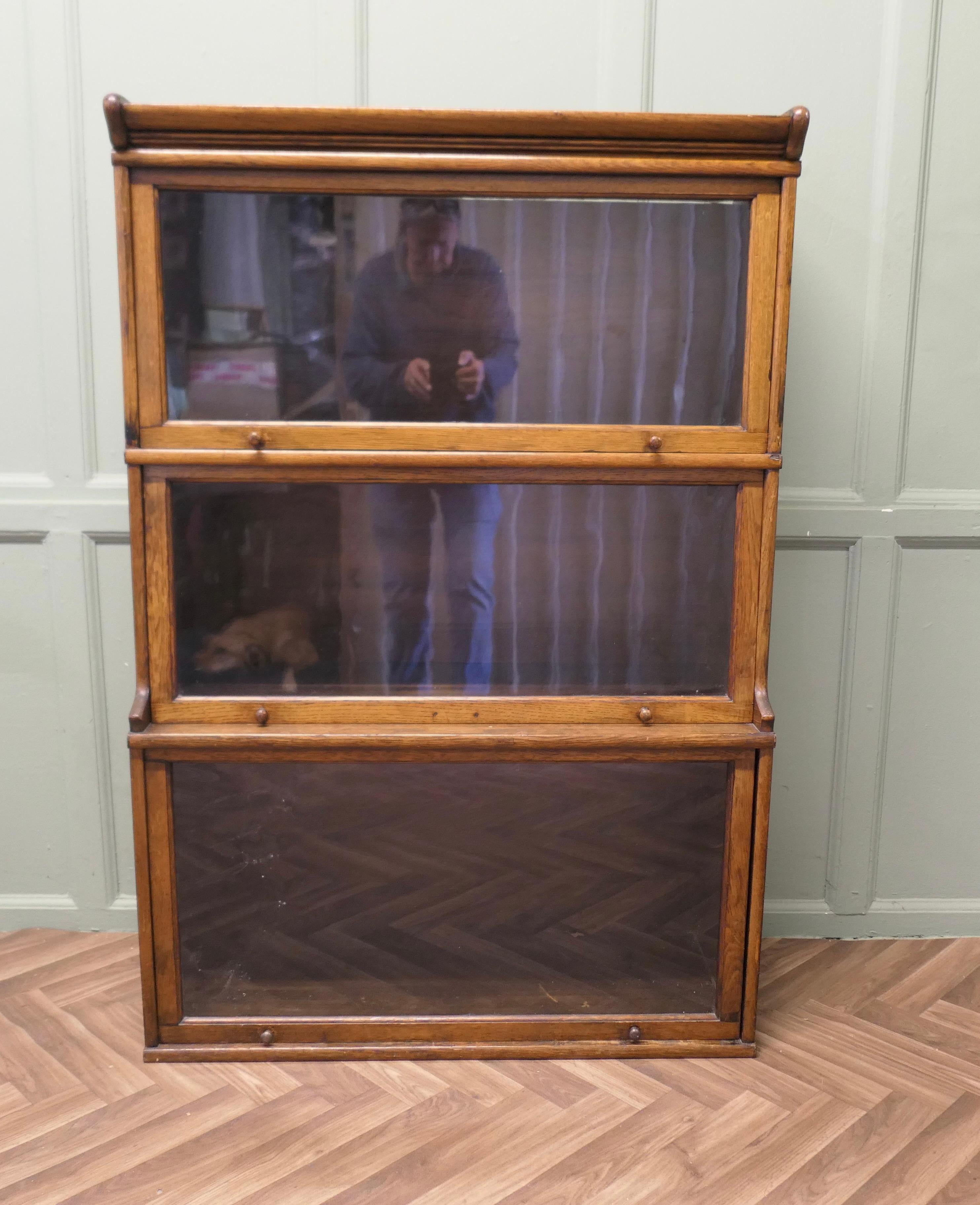 Arts and Crafts Stacking Barristers Bookcase or Filing Cabinet

This is a good quality Oak Bookcase, all of the sections have a glazed up and over door, just a quick mention, the old rolled glass is especially noticeable on the bottom door it is a