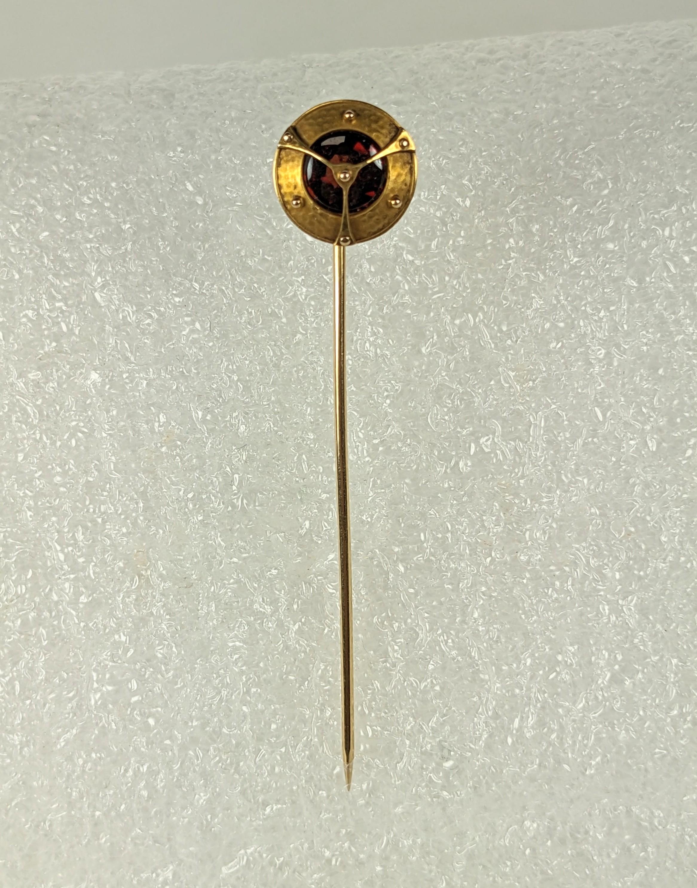 Unusual Arts and Crafts Steampunk Garnet Stickpin in 14k gold. Hand hammered surround with straps laid over a round garnet. Unusual garnet cut in the that the top is cabochon (uncut) and the back is faceted so that when the light hits, it flickers