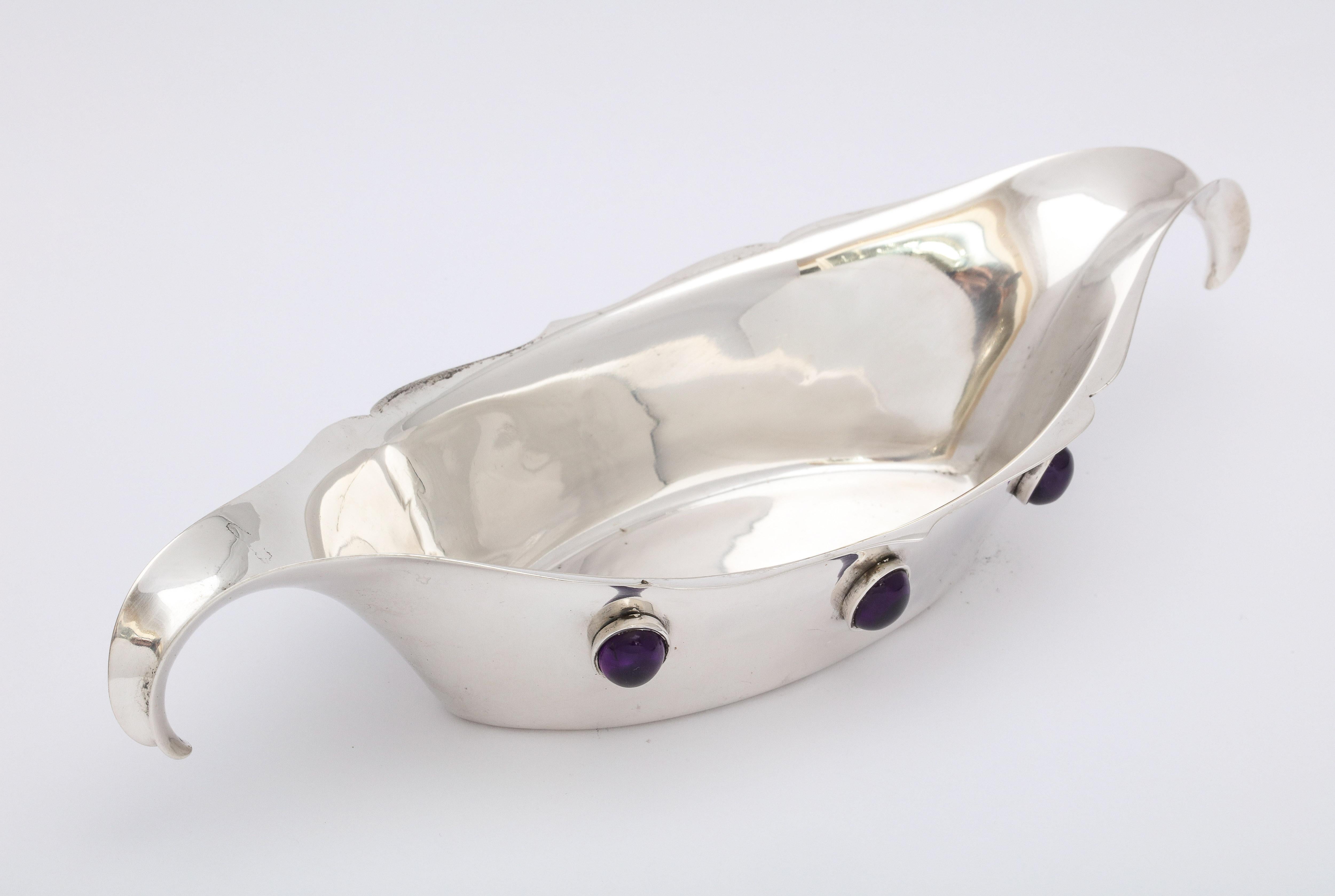 Arts & Crafts, sterling silver bowl inset with cabochon cut, bezel set amethysts, The Watson Silver Co., Attleboro, Mass., circa 1920s. Graceful curve to handles. Lovely design. Measures: 8 3/4 inches wide x 3 1/4 inches deep x 1 3/4 inches high at