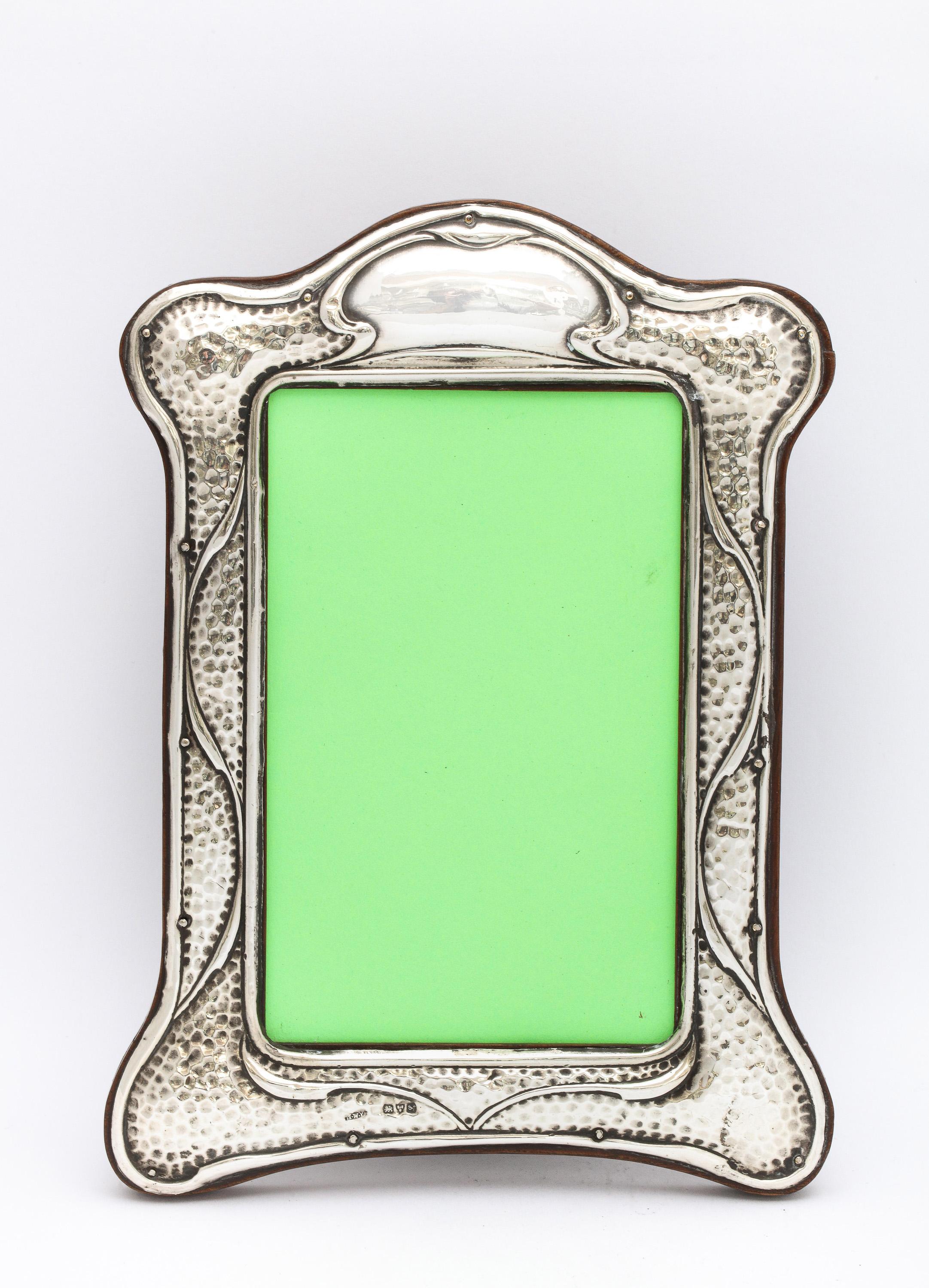 Cadre photo Arts and Crafts, en argent sterling, avec dos en bois, Chester, Angleterre, année 1911, H. Williamson, Ltd. - fabricant. Un beau design martelé. Cartouche vide. Mesure près de 8 pouces de haut (au point le plus haut) x 5 3/4 pouces de