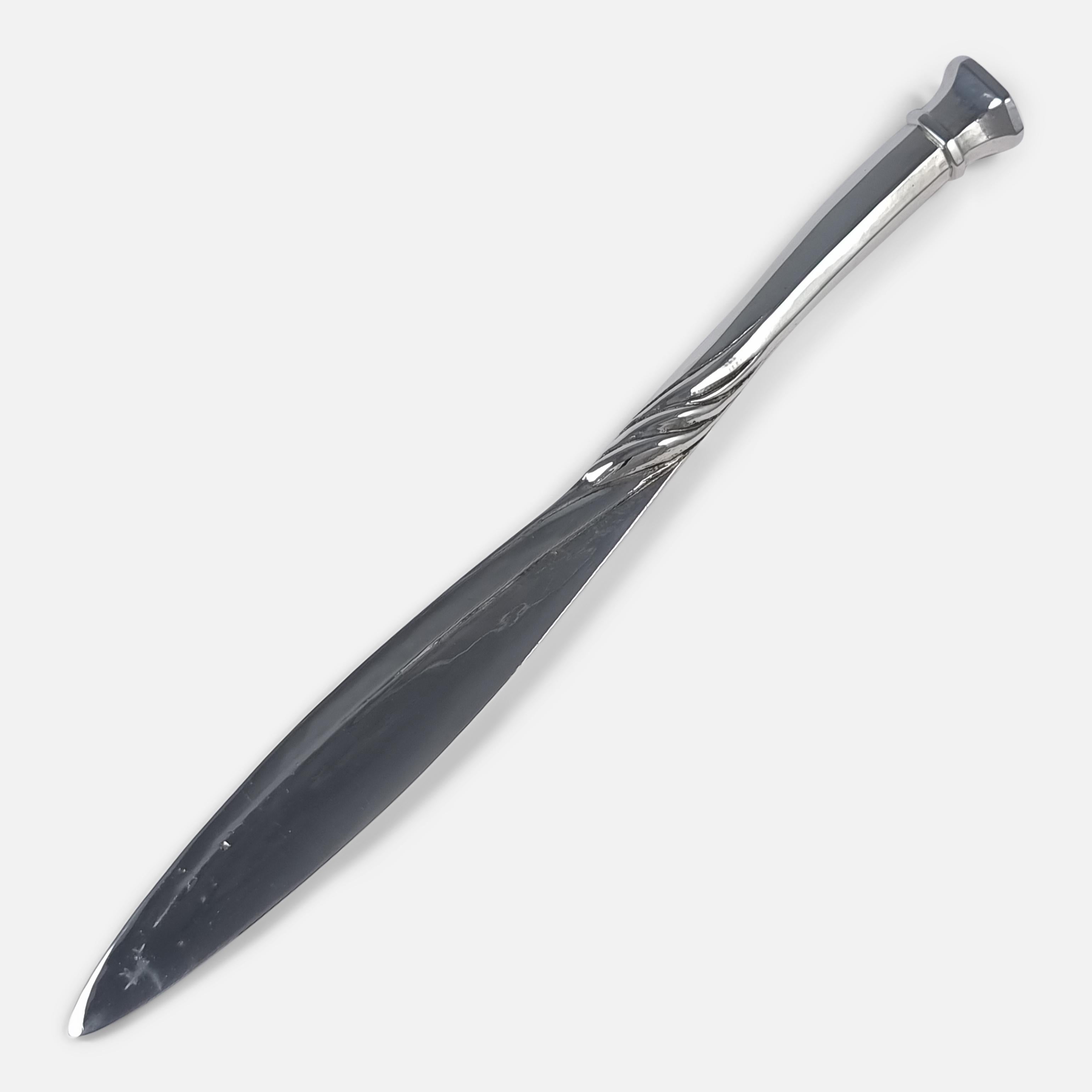 An Arts and Crafts sterling silver Paper Knife (or Letter Opener) by Omar Ramsden and Alwyn Carr. The paper knife is crafted with a tapering blade, and spot-hammered decoration, the faceted handle with fluted decoration and an octagonal seal-top