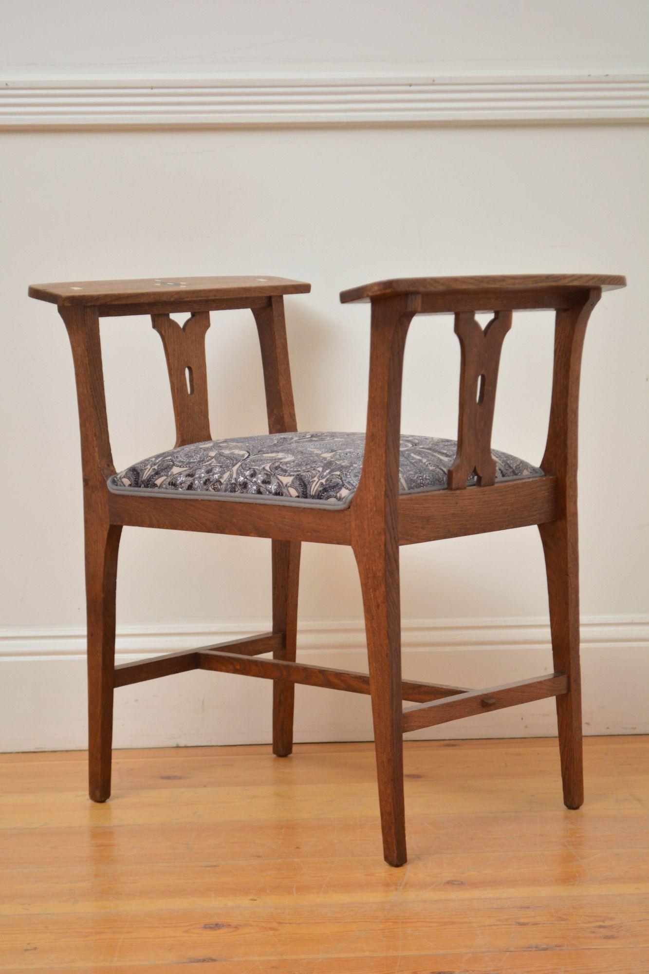 Sn5603 Stilvoller Hocker im Arts-and-Crafts-Stil mit neu gepolstertem Sitz aus dunkelgrauem und beigem Blumenstoff, flankiert von geometrisch eingelegten Armlehnen mit geschnitzten Stützen, die auf vier quadratischen, konischen Beinen stehen, die