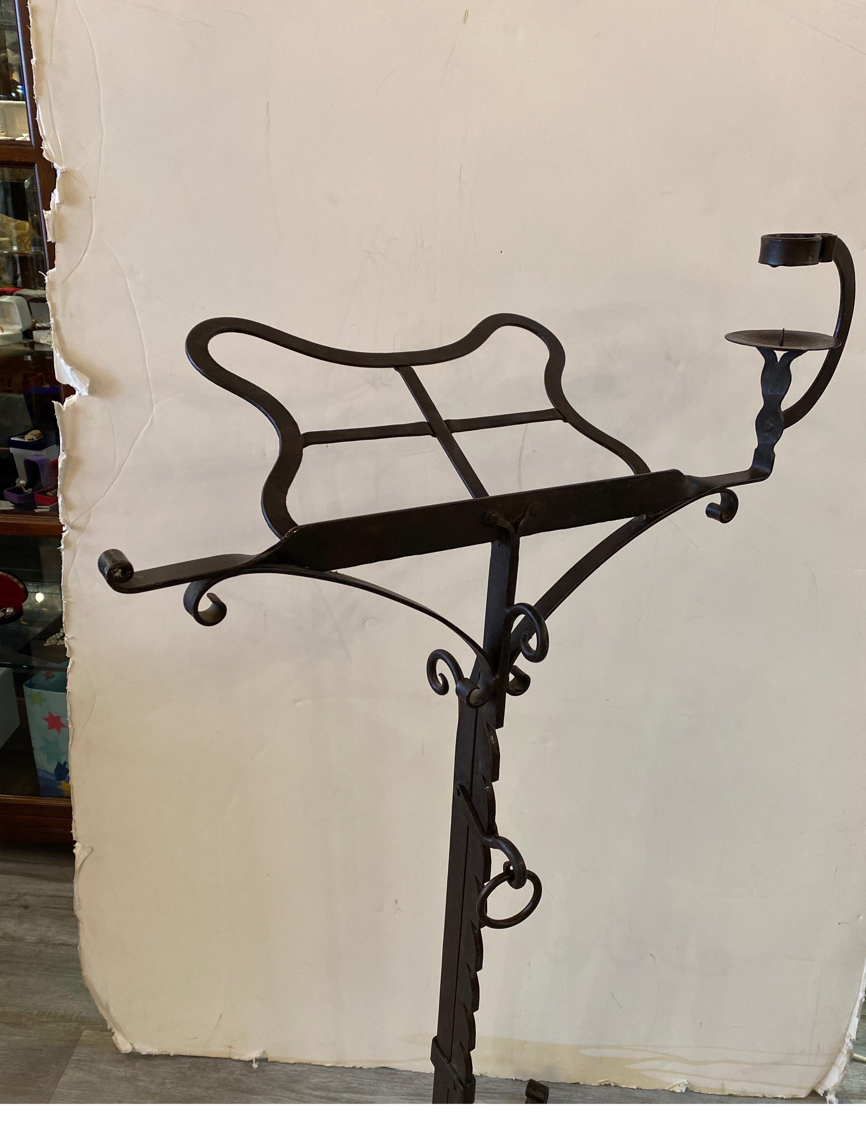 Handsome hand forged wrought iron adjustable lectern music stand. The adjustable height from 46.5 up to 32 inches tall. The upper part with a place for a candle with an adjustable center column, resting on a tripod base. This was black smith made