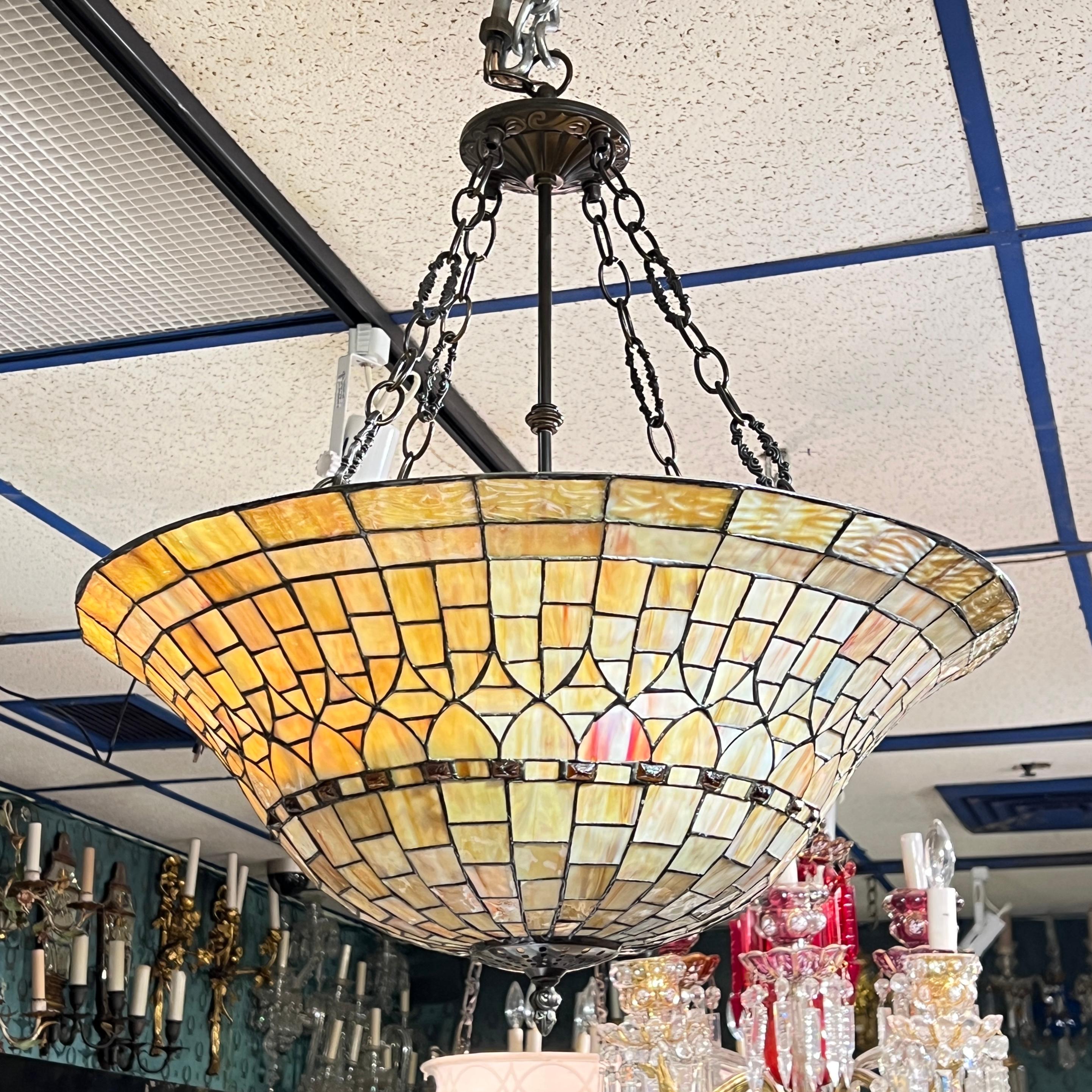 Beautiful leaded stained glass chandelier with various shades of yellow, gold and peach colored glass, 23 1/2 inches across and 27 1/2 inches tall from the top of the hook to the lower finial.  With three standard Edison e26 sockets and wiring ready