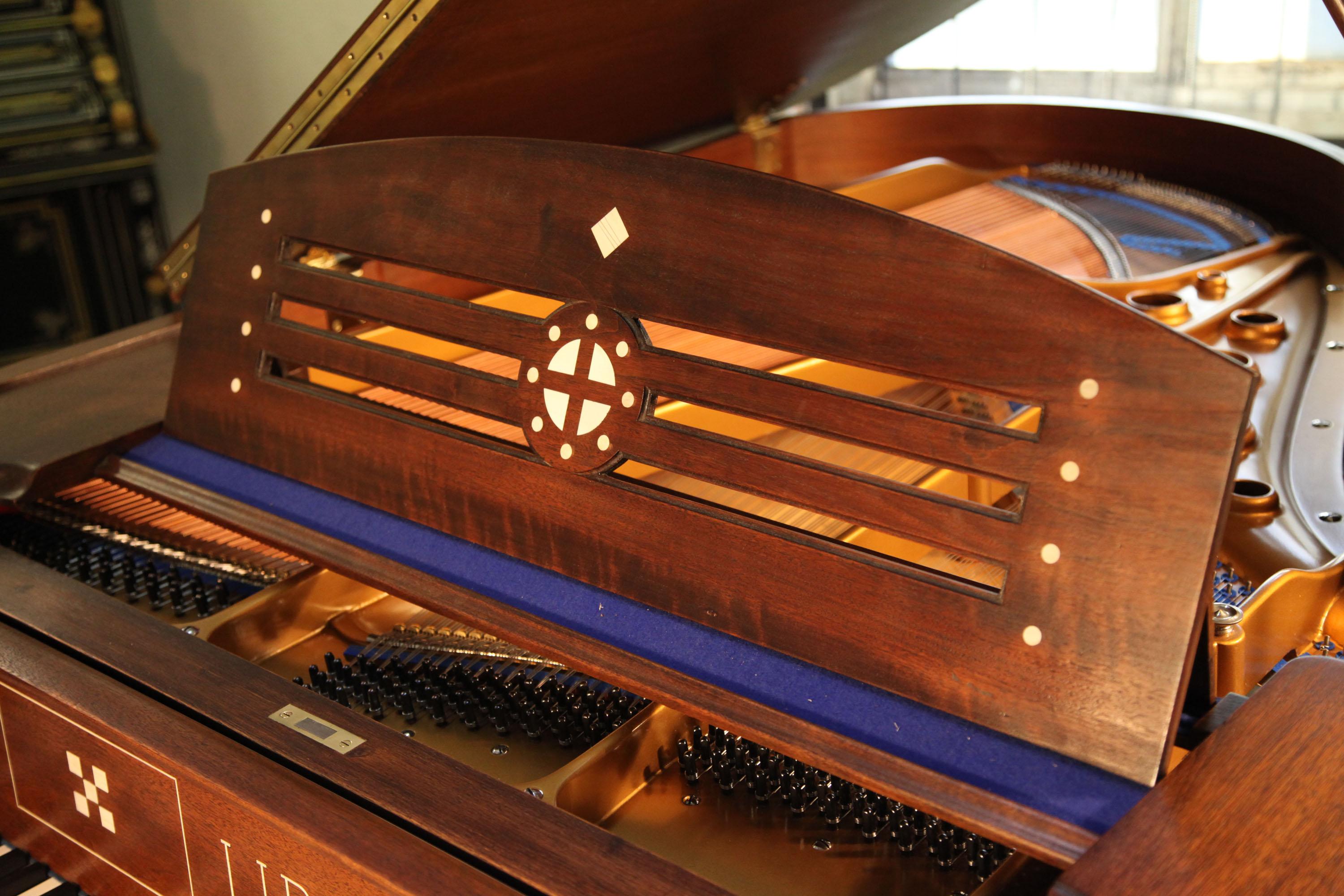 Arts and Crafts style, Lipp grand piano for sale with a mahogany case inlaid with symbols and designs from Germanic folklore. Case features ornate brass hinges and slatted cross stretcher. The mahogany cabinet is polished in matt to emphasize the