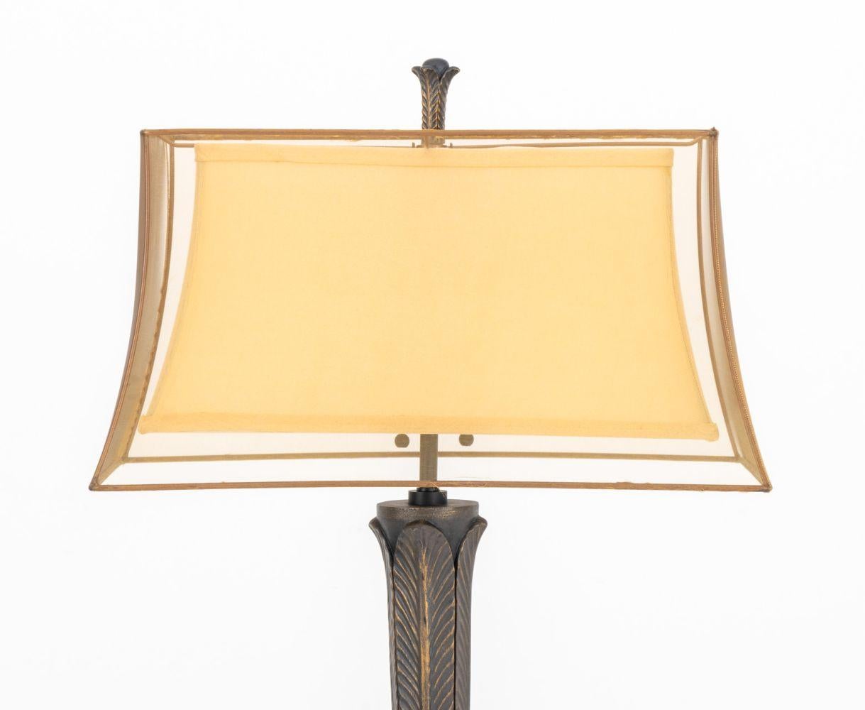 Lámpara de pie de caoba estilo Arts and Crafts, con pantalla de malla y una mesa auxiliar en el centro del soporte central de hoja de acanto tallada montada, sobre una base octogonal.

65