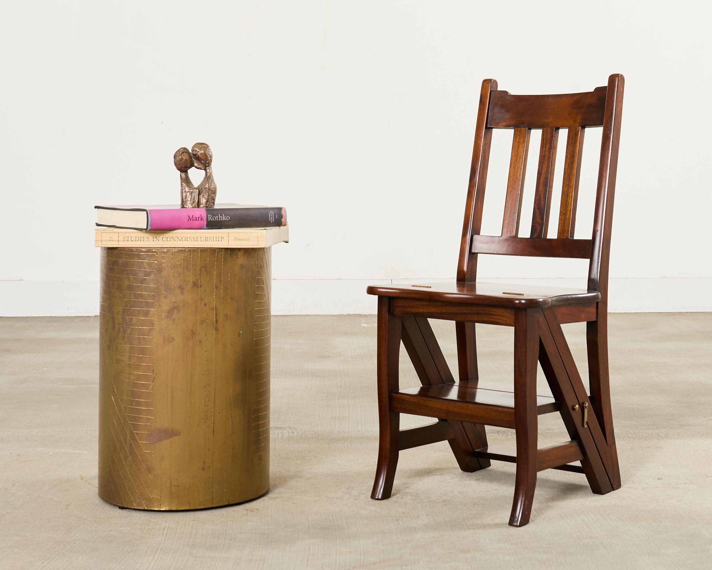Handsome solid mahogany metamorphic library chair that converts into a step ladder made in the English Arts and Crafts style. The chair is sturdy and solid with brass hardware and locks. The chair measures 26 inches deep when opened as a step