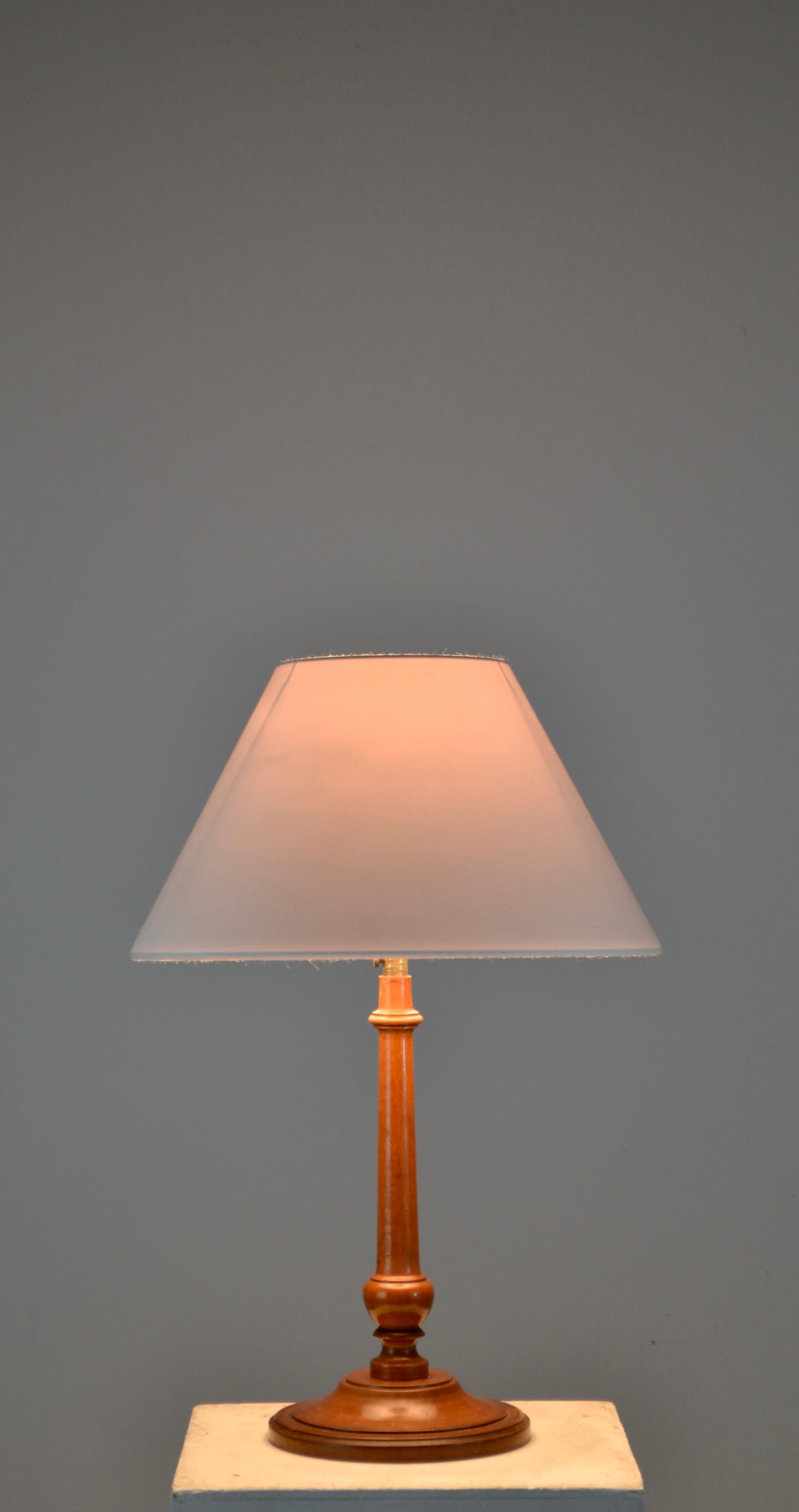 Elegante lámpara de sobremesa francesa de estilo Arts and Crafts, de principios del siglo XX. El esbelto tallo está finamente torneado en madera de boj, mostrando una cálida y rica pátina que refleja la calidad de la artesanía. Bajo la base se
