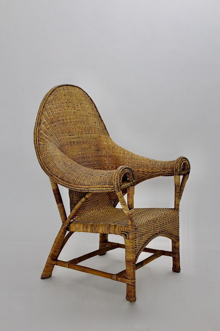 Arts & Crafts period Vintage wicker rattan armchair or lounge chair, which was designed and manufactured by Dryad & Co attributed, circa 1910, U.K.
The cane armchair shows amazing curved armrests, which features movement and elegance into the