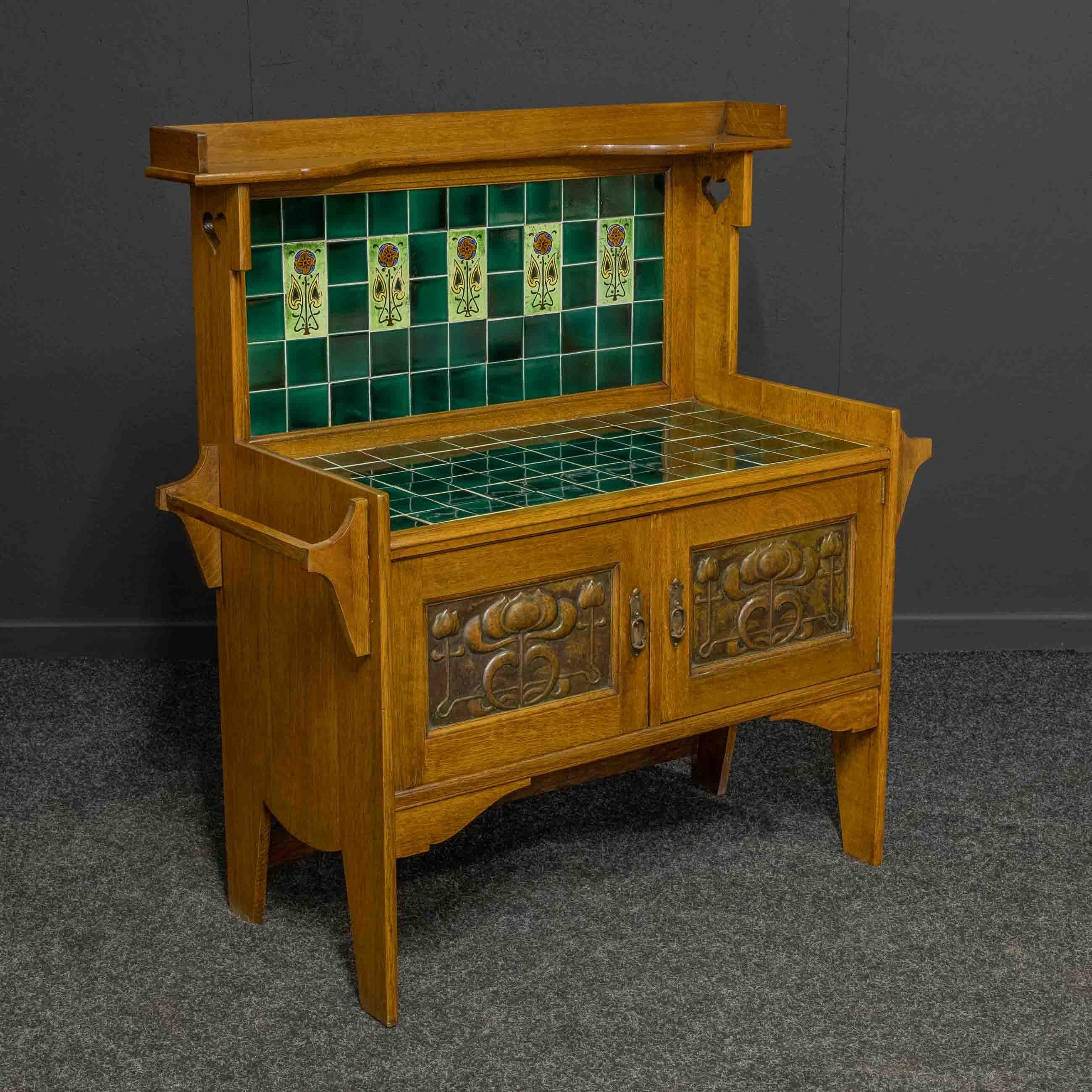 An absolutely stunning Arts and Crafts washstand from the late Victorian period. Made from solid oak with beautiful embossed copper panels to the pair of cupboard doors which also retain their original handles. The legs are cut from the solid sides